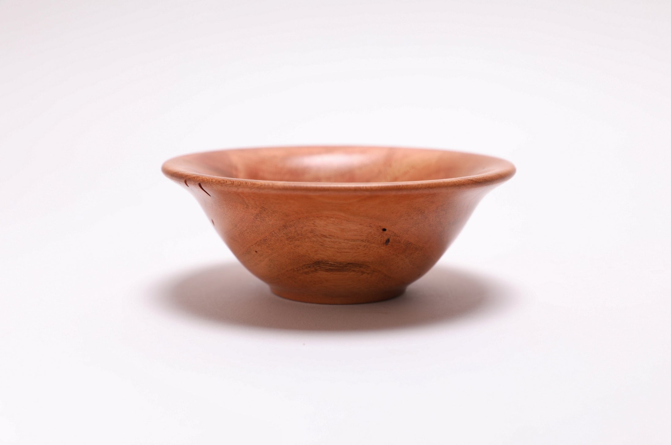 Small wild black cherry wooden bowl side view showing 1 3/4 inch depth and exaggerated bell shape, handmade in NC