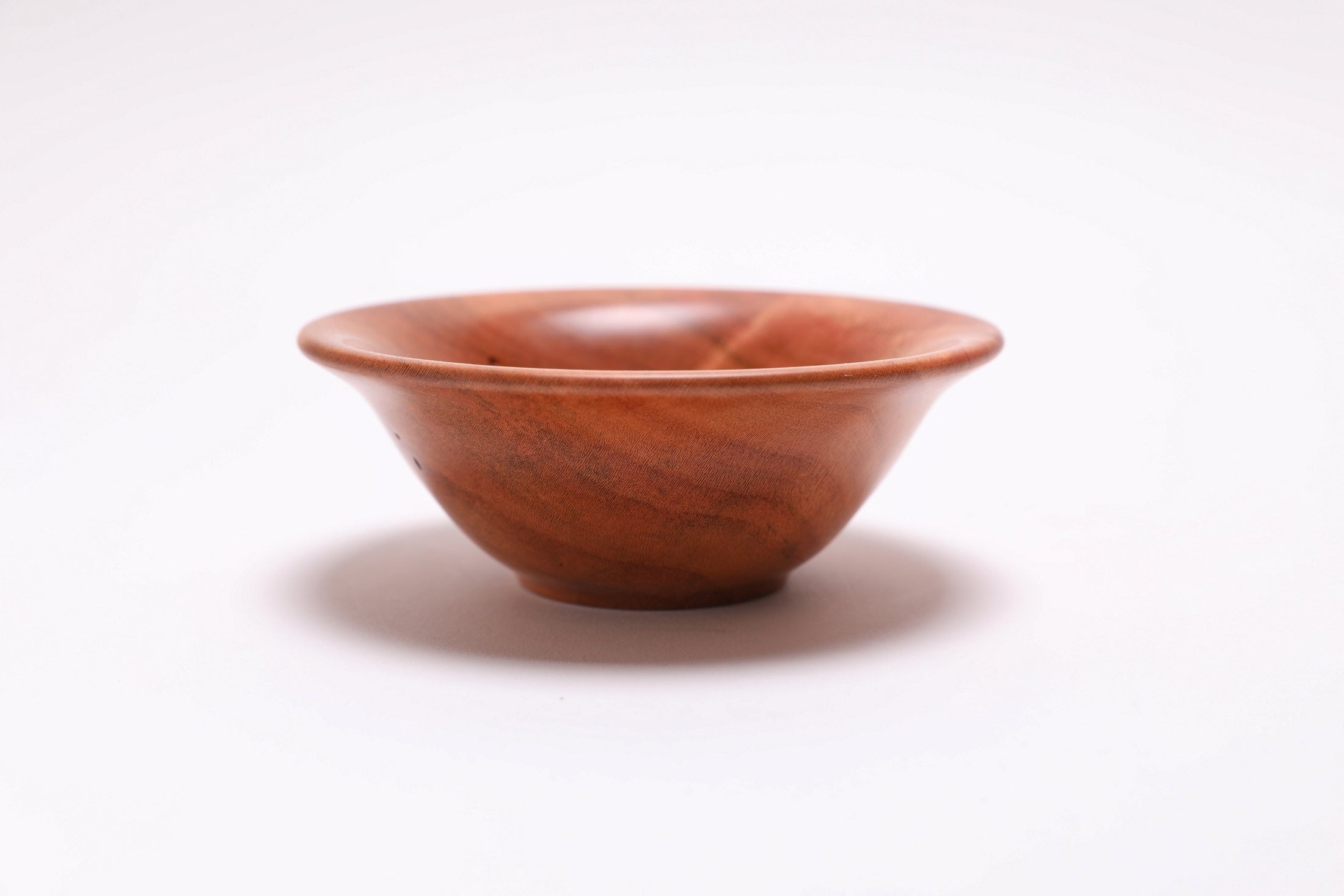 Small wild black cherry wooden bowl side view rotated 90 degrees showing soft rounded rim profile
