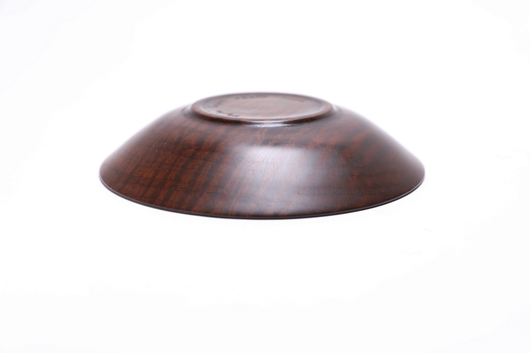 Thermally modified tiger maple wooden bowl side view of bottom showing raised foot and natural wood character