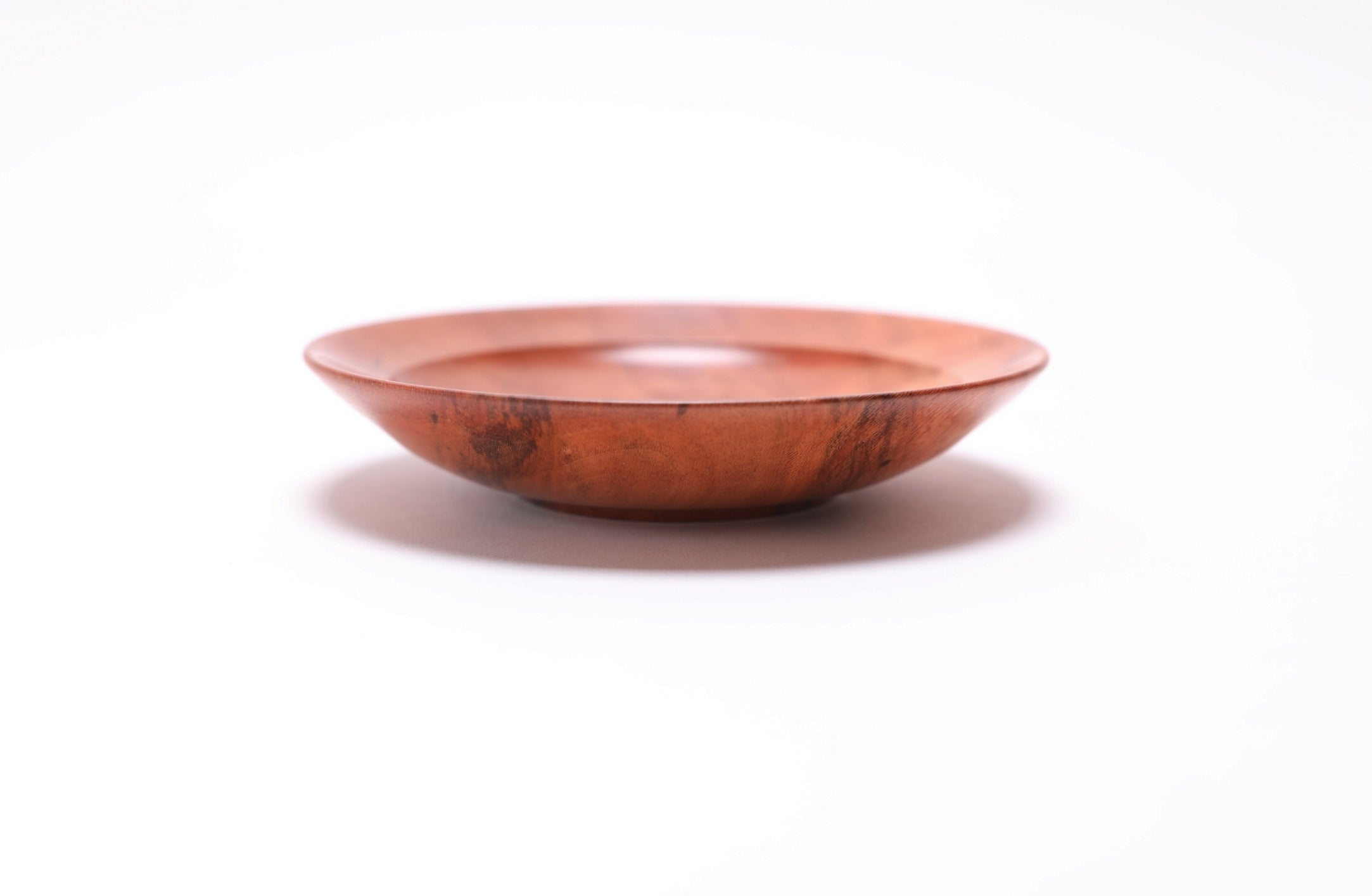 Wild black cherry wooden ring dish, side view at 0°, showing raised foot and curved taper profile