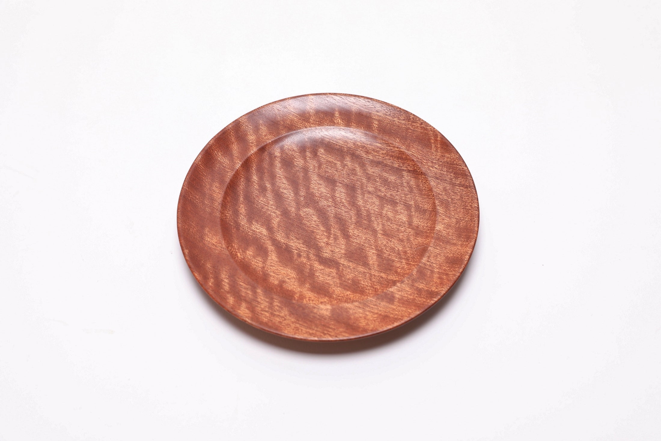Pommele ribbon sapele wooden ring dish, top view rotated 45°, rich chatoyant shimmer and ribbon pattern
