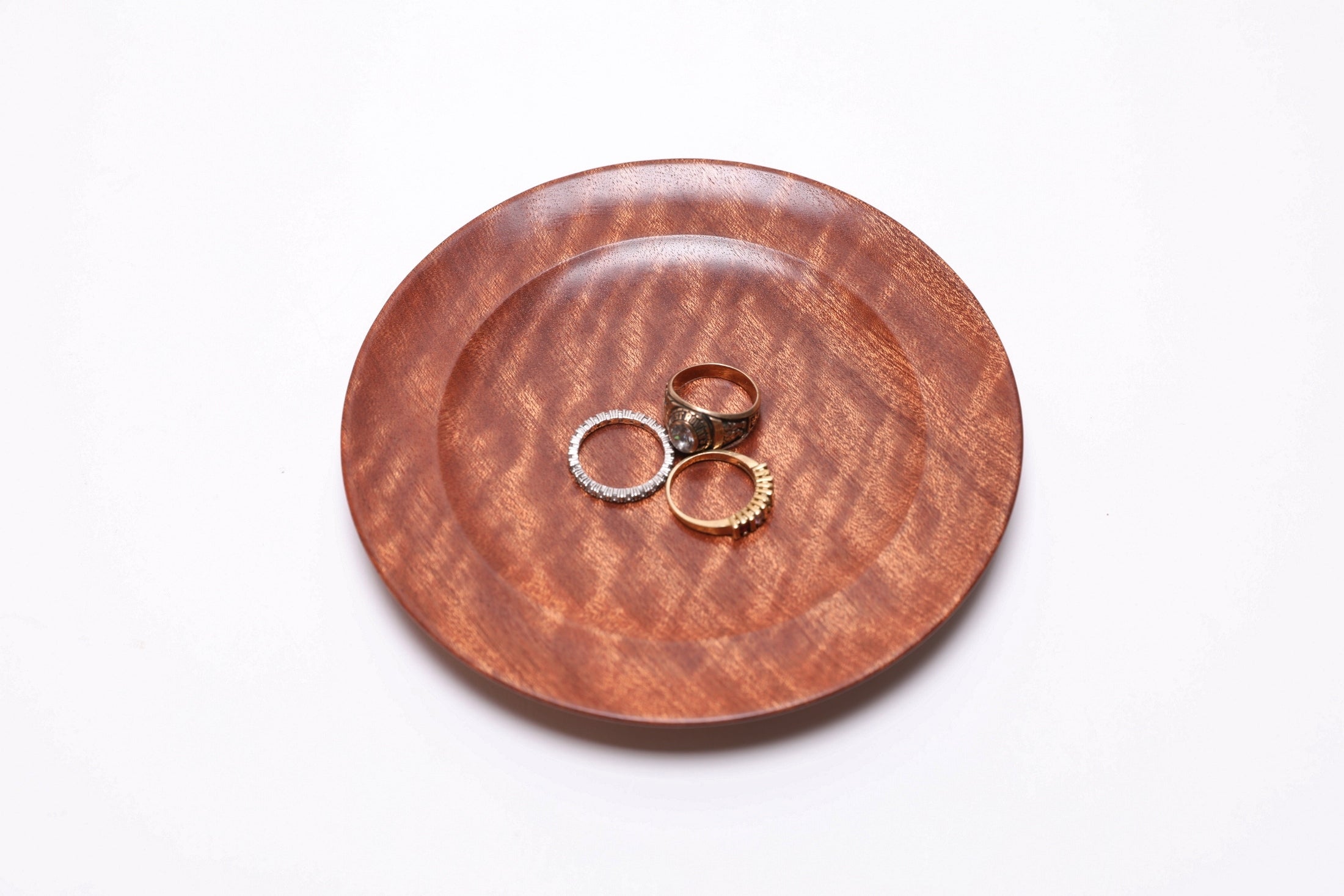 Pommele ribbon sapele wooden ring dish shown with three rings for scale — rings not included