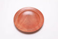 Wild black cherry wooden ring dish, top view at 0°, showing deep pink-orange tones and natural grain