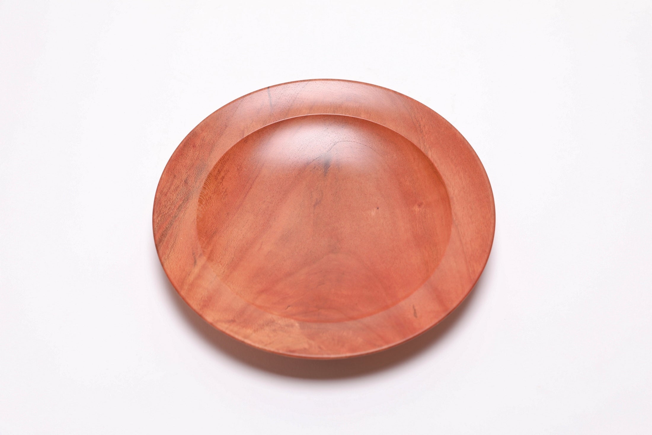 Wild black cherry wooden ring dish, top view at 0°, showing deep pink-orange tones and natural grain