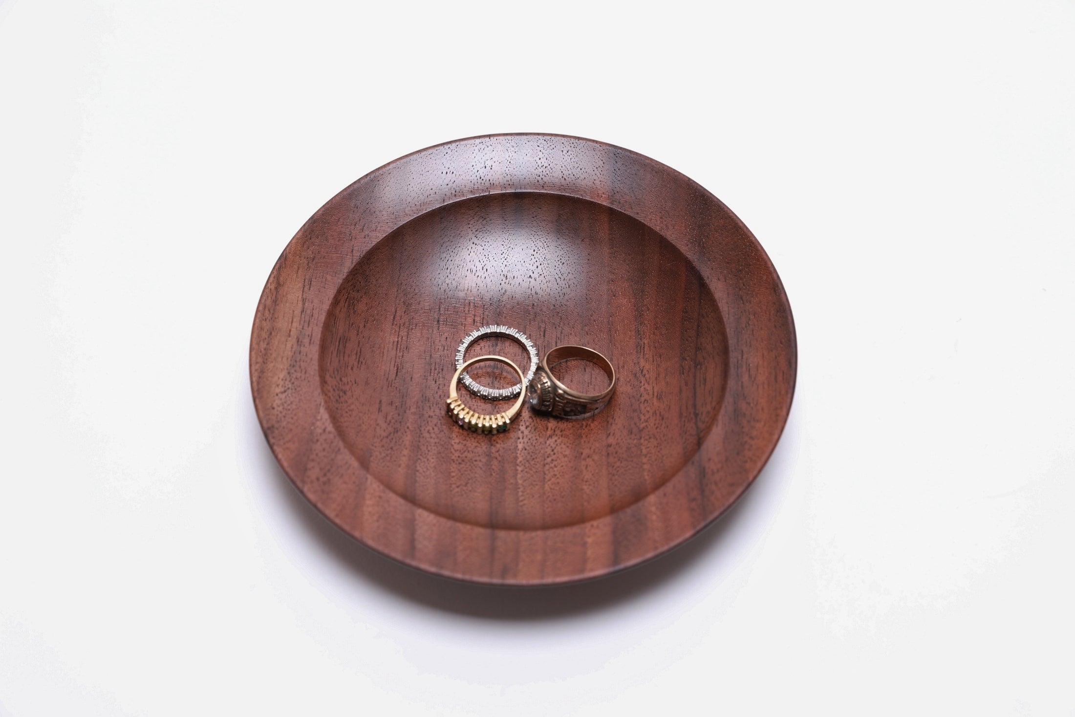 Quartersawn wild black walnut wooden ring dish shown with three rings for scale — rings not included
