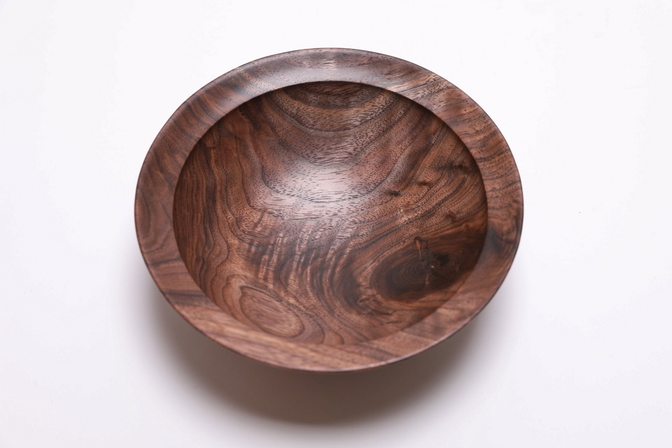 Wild black walnut crotch burl wooden bowl, top view at 90°, highlighting curly growth rings and dark chocolate tones