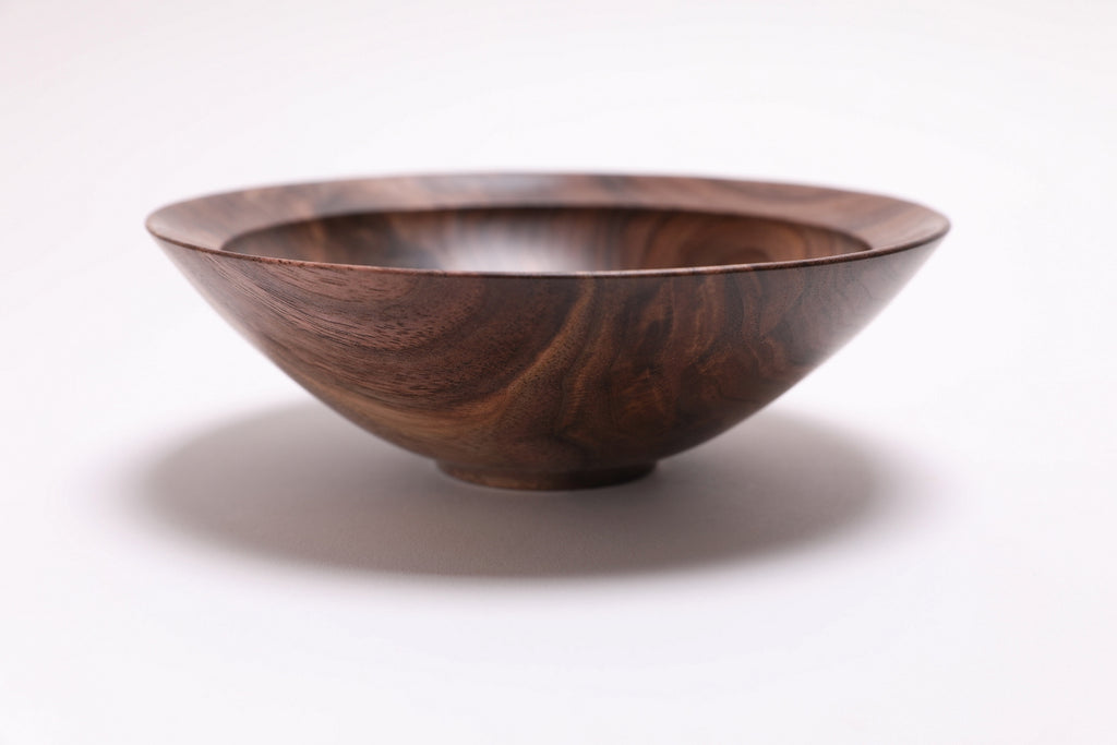 Wild black walnut crotch burl wooden bowl, side view at 270°, raised foot and rich walnut color visible