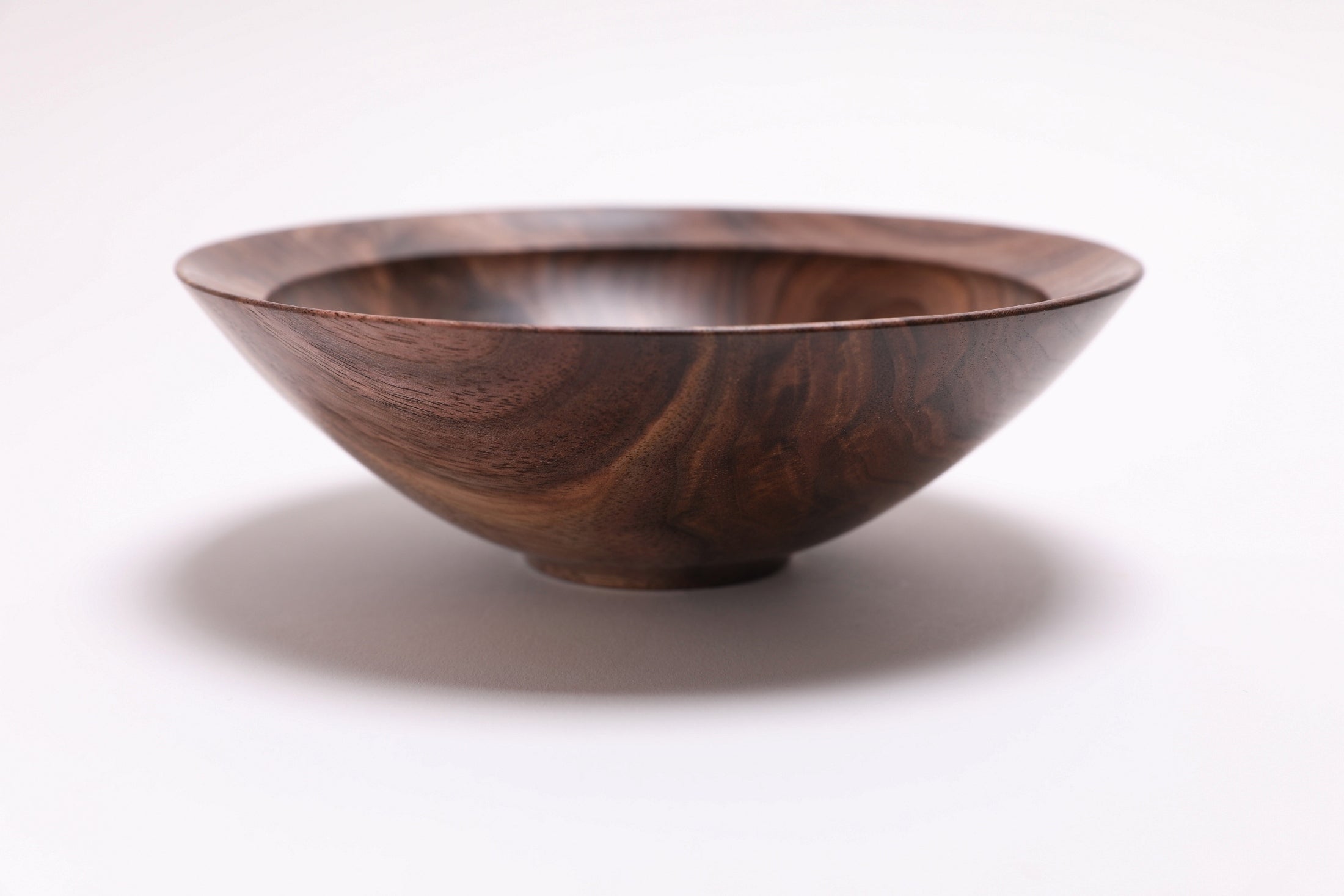 Wild black walnut crotch burl wooden bowl, side view at 270°, raised foot and rich walnut color visible
