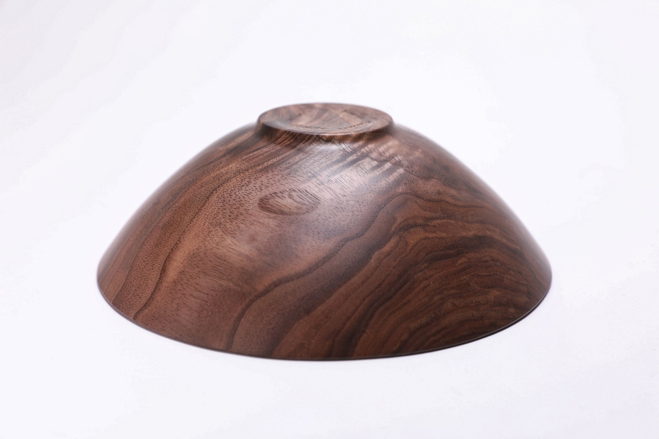 Wild black walnut crotch burl wooden bowl, bottom view showing raised foot and natural finish
