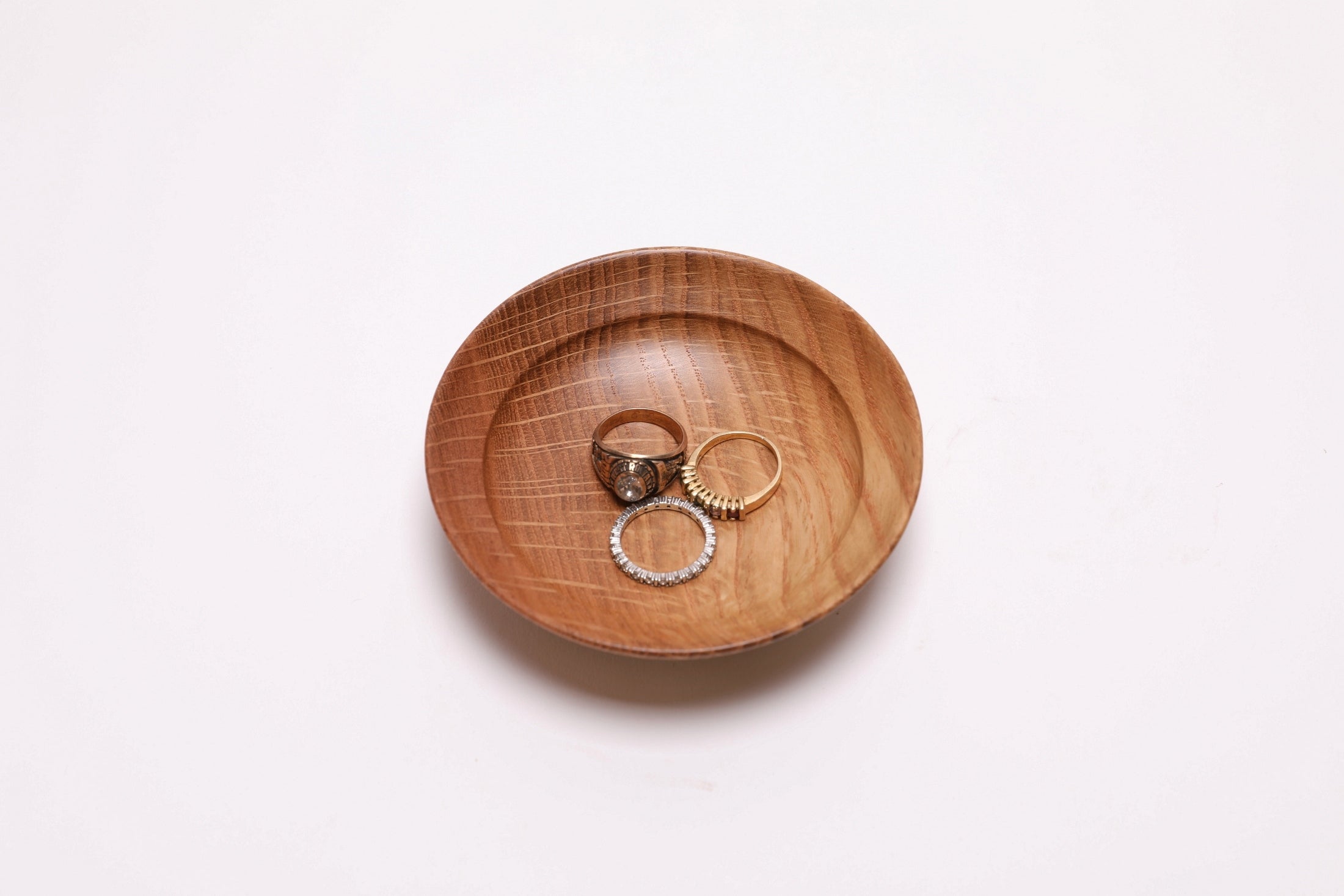 Quartersawn white oak wooden ring dish shown with three rings for scale — rings not included