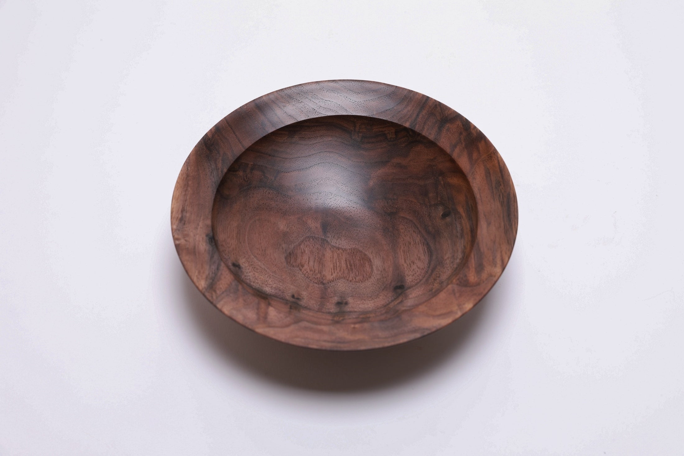 Curly wild black walnut wooden bowl, top view at 180°, stunning curly grain and amber to dark chocolate tones