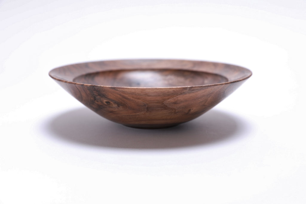 Curly wild black walnut wooden bowl, side view at 270°, raised foot and rich walnut color visible