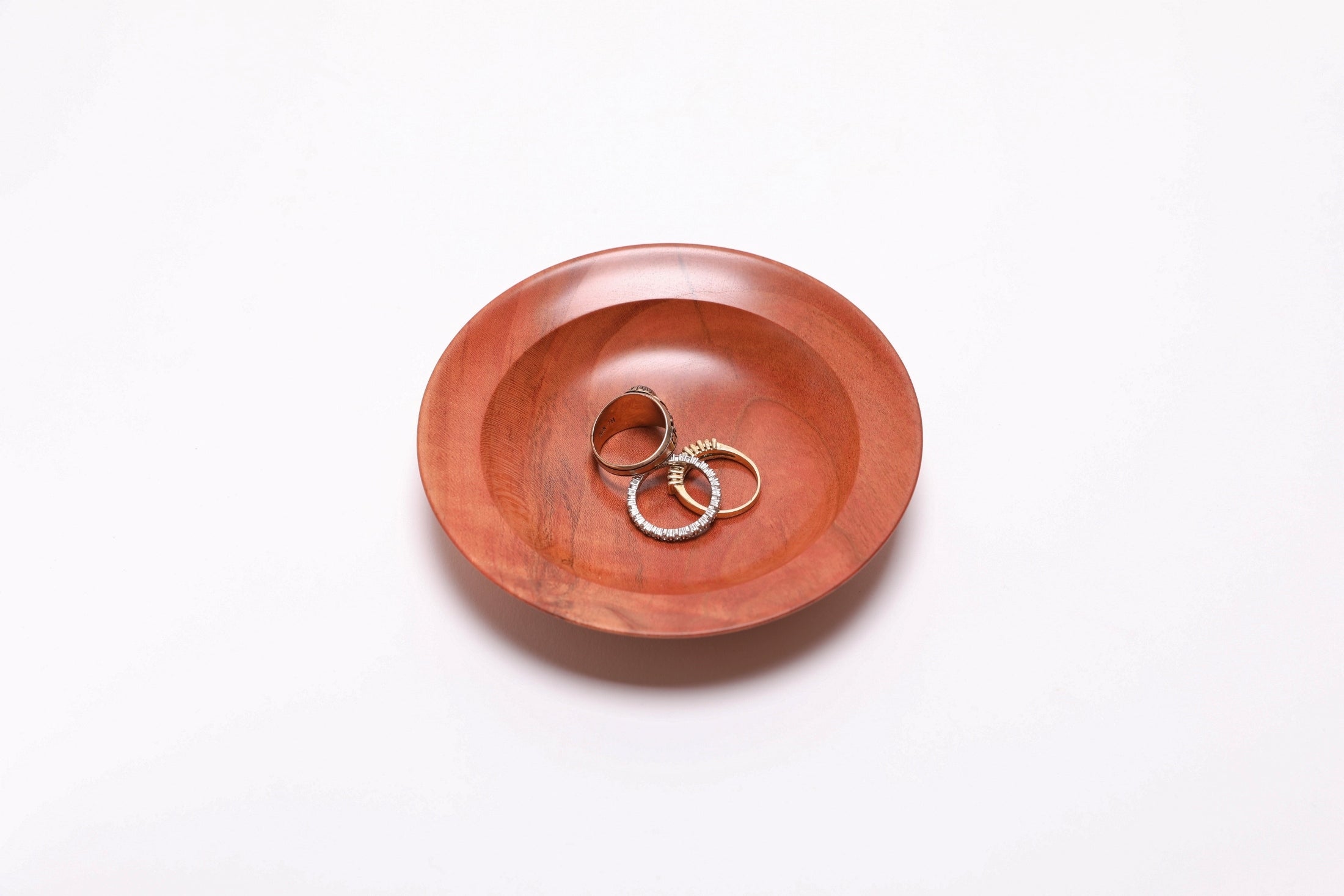 Wild black cherry wooden ring dish with three rings for scale, 4 5/8 x 7/8 inches