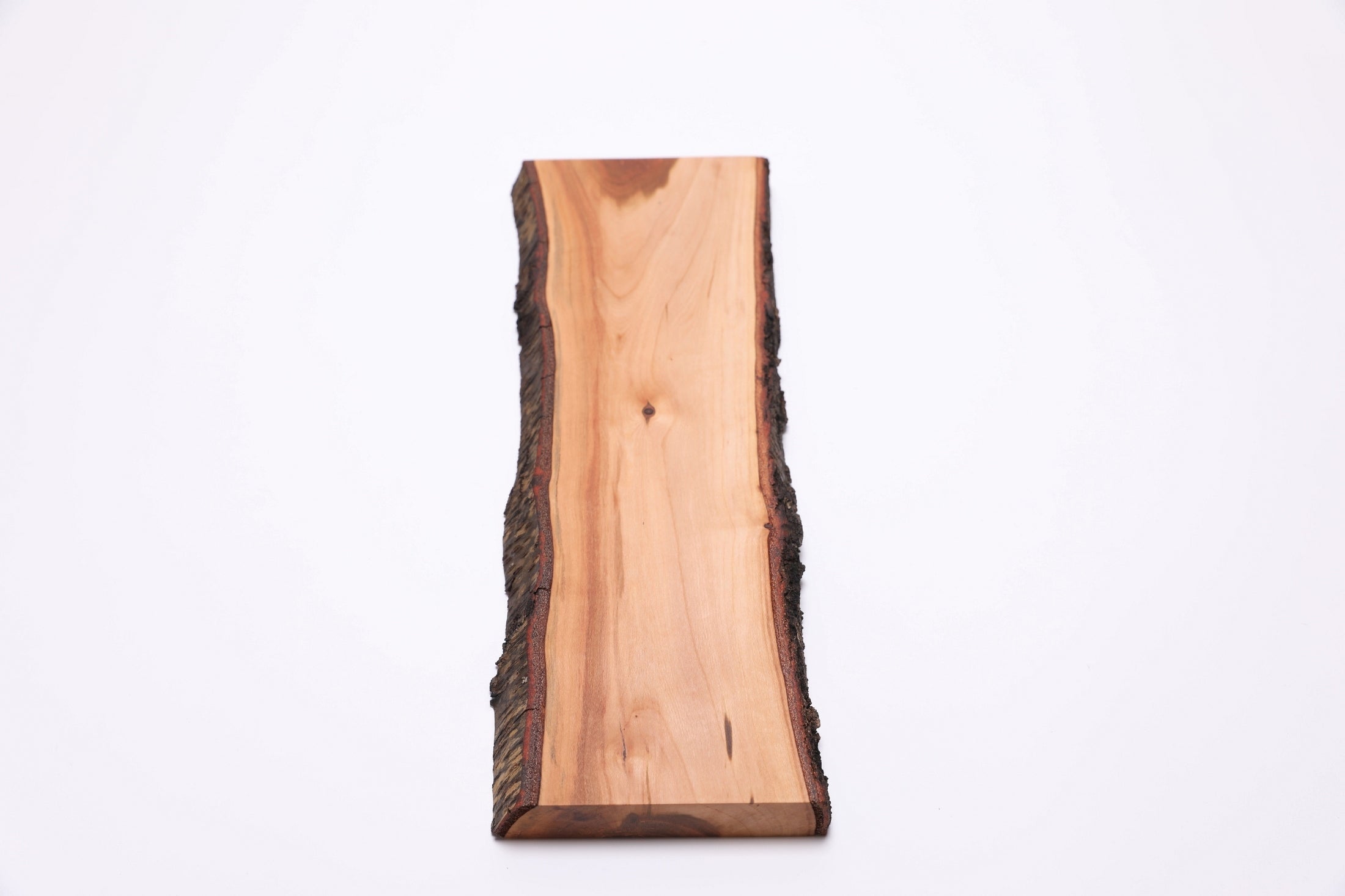 Live-edge wild black cherry serving board, angled top view highlighting natural bark and grain pattern