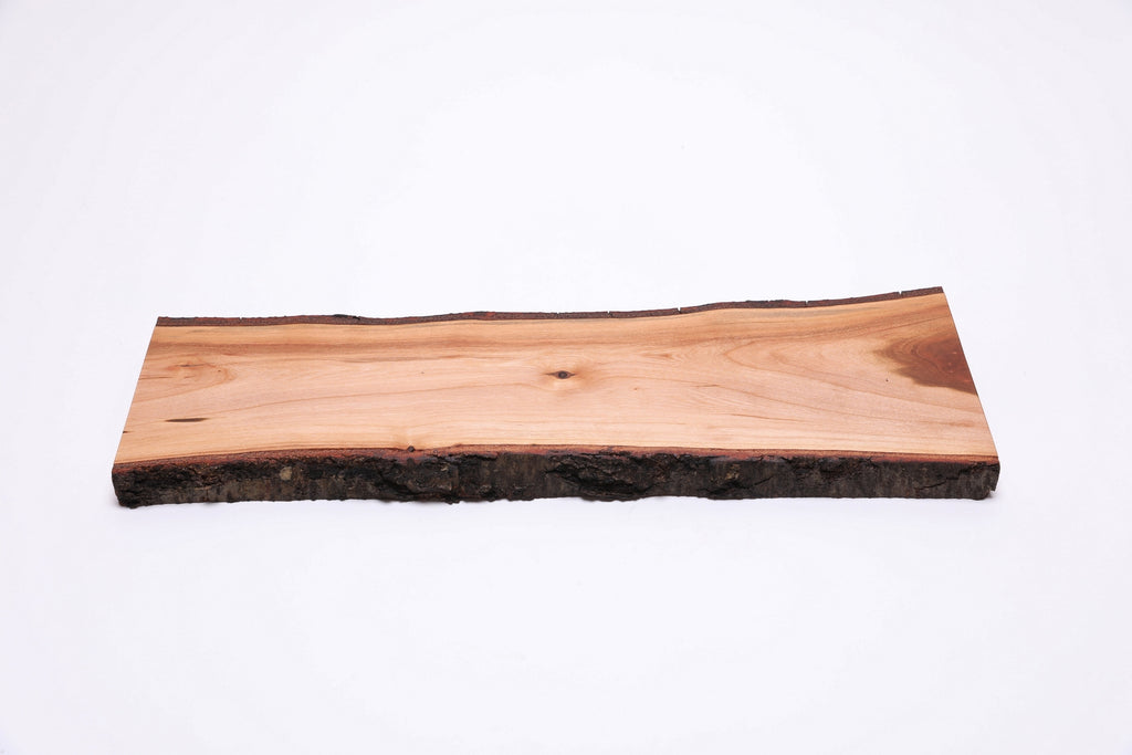 Close-up top view of black cherry charcuterie board showing live bark edge detail and natural wood character