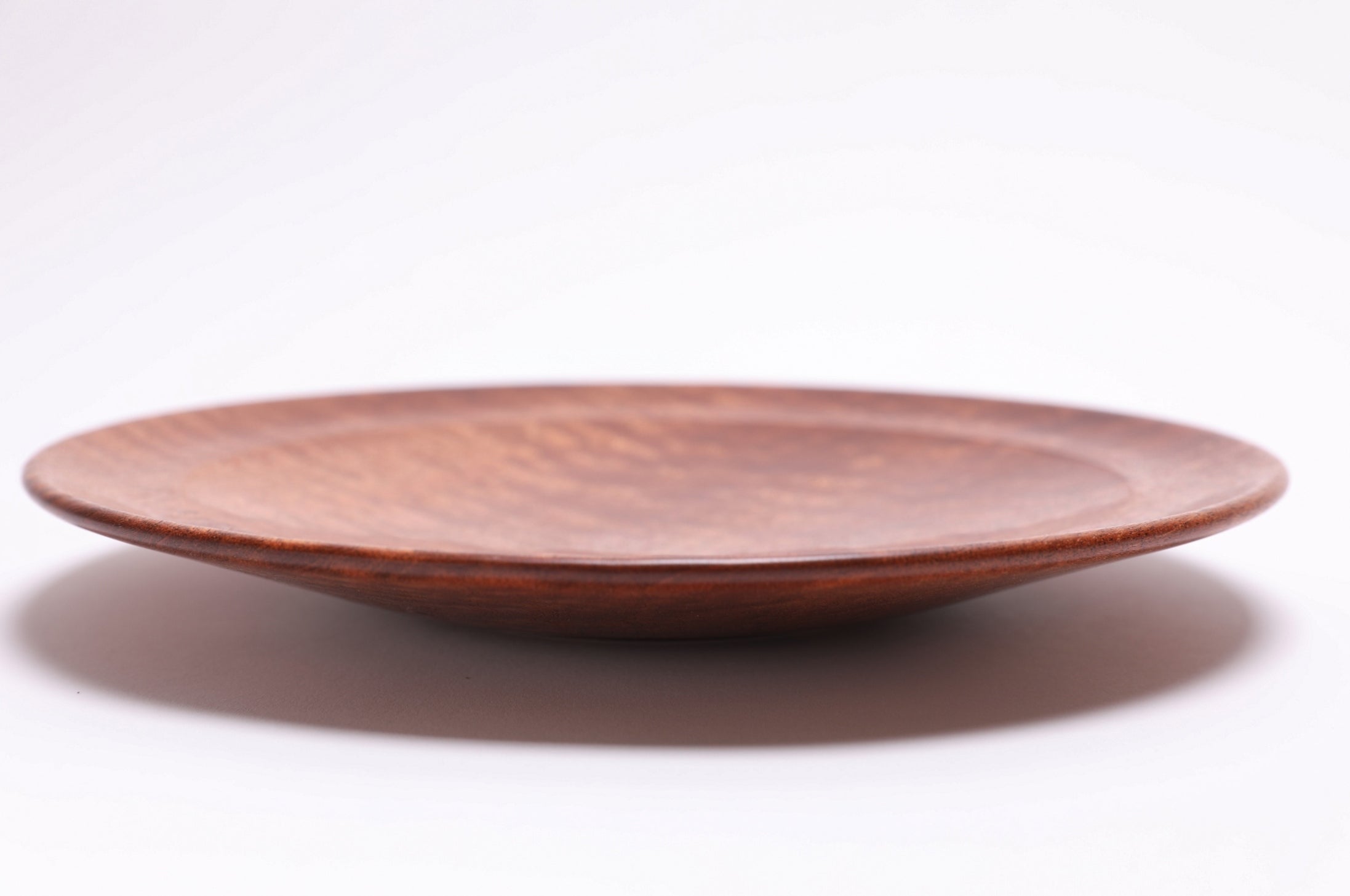 Pommele sapele shallow bowl side view, curved taper and raised foot profile