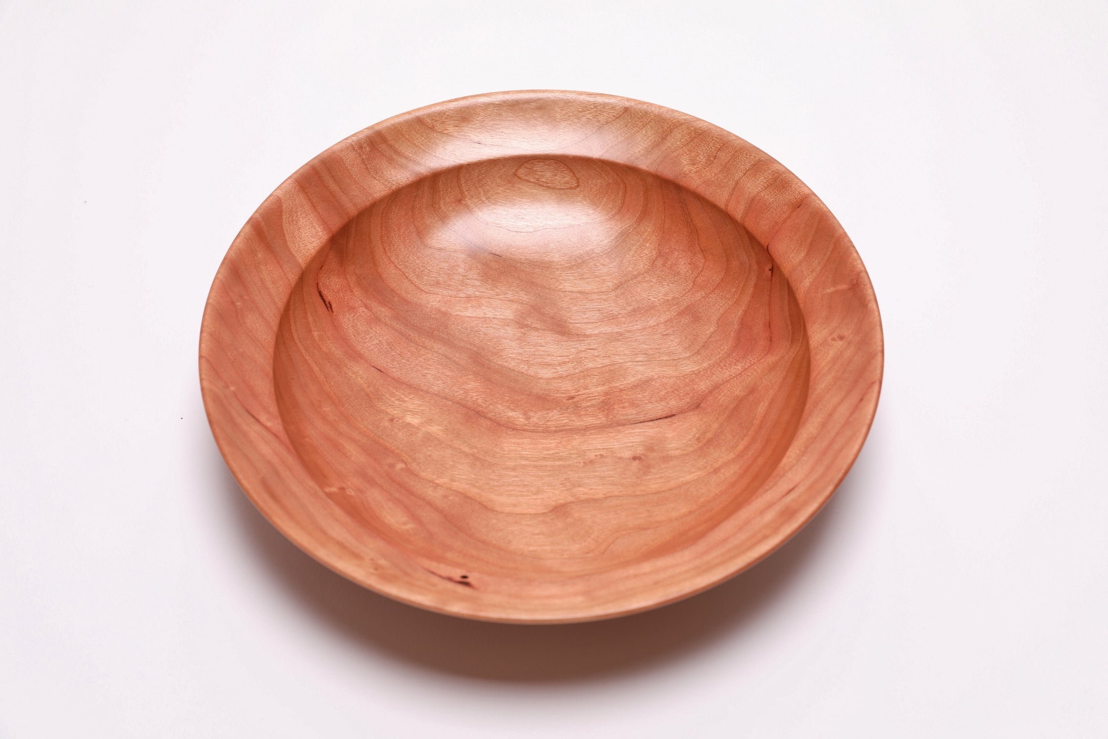Wild black cherry wooden bowl top view 0 degrees, chatoyant figure and amber growth rings, handmade by Sanders Woodworking