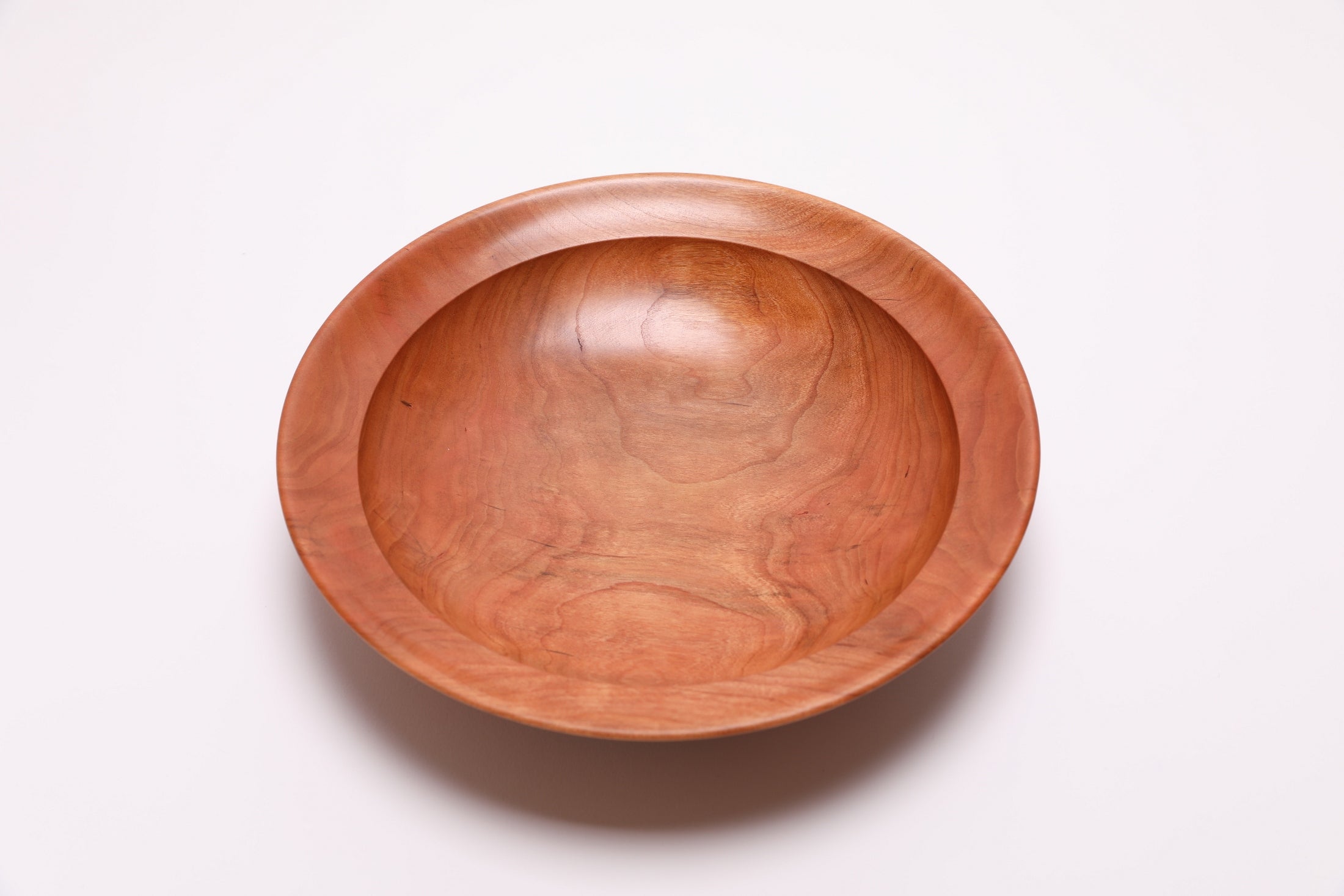Handcrafted wild black cherry wooden bowl, top view – rich orange-pink grain with amber growth ring lines, 10 1/8" diameter