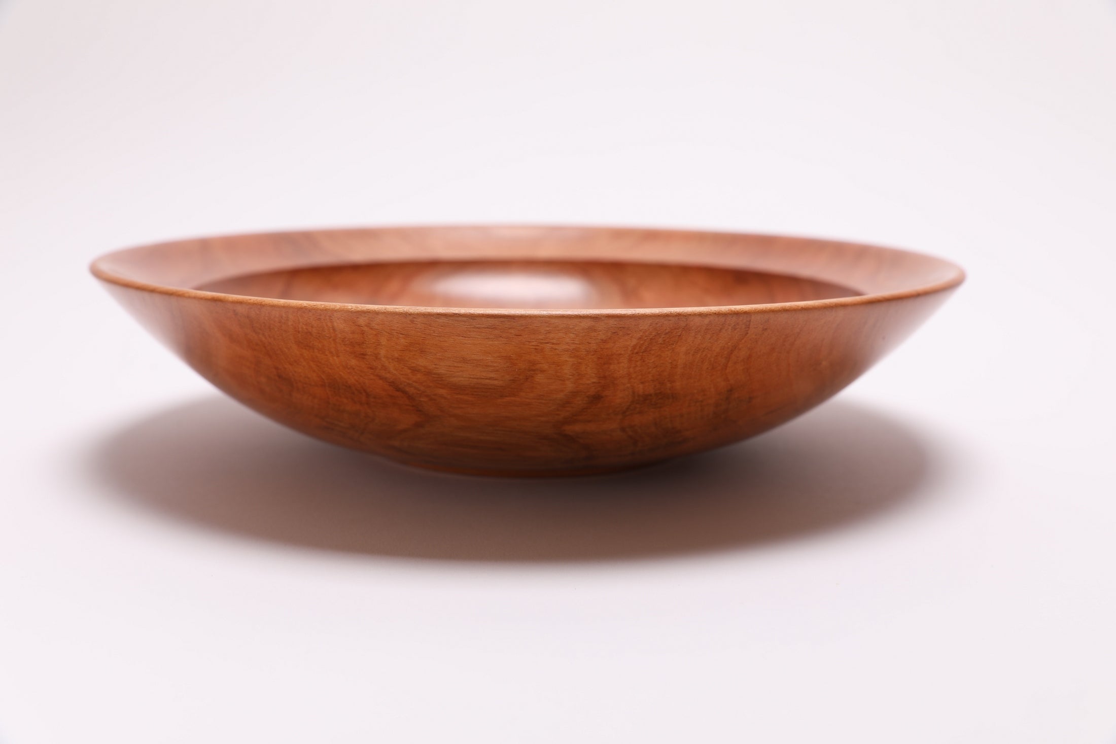 Wild black cherry wooden bowl side view rotated 180°, curved profile and raised foot detail