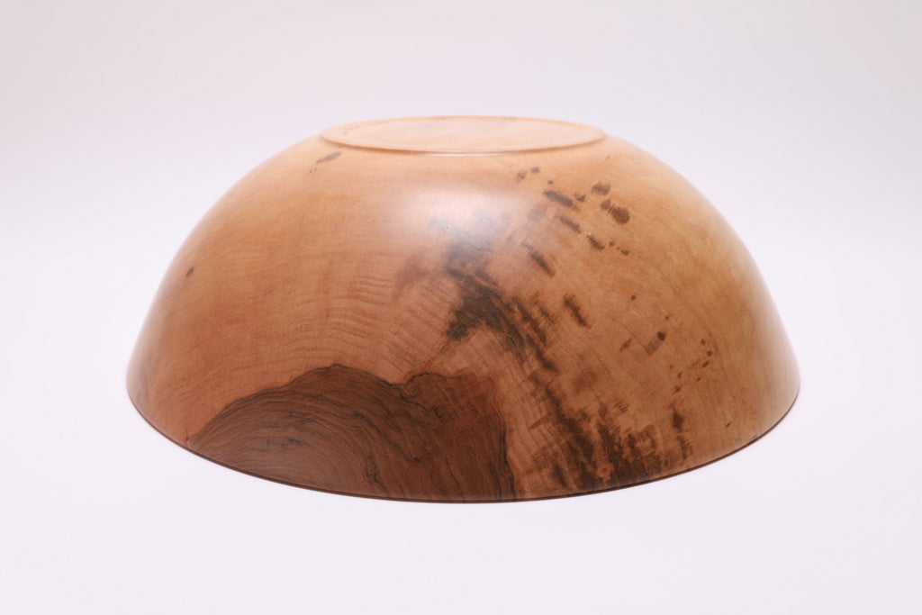 Bottom view of handcrafted large sugar maple bowl showing raised foot and food-safe oil finish
