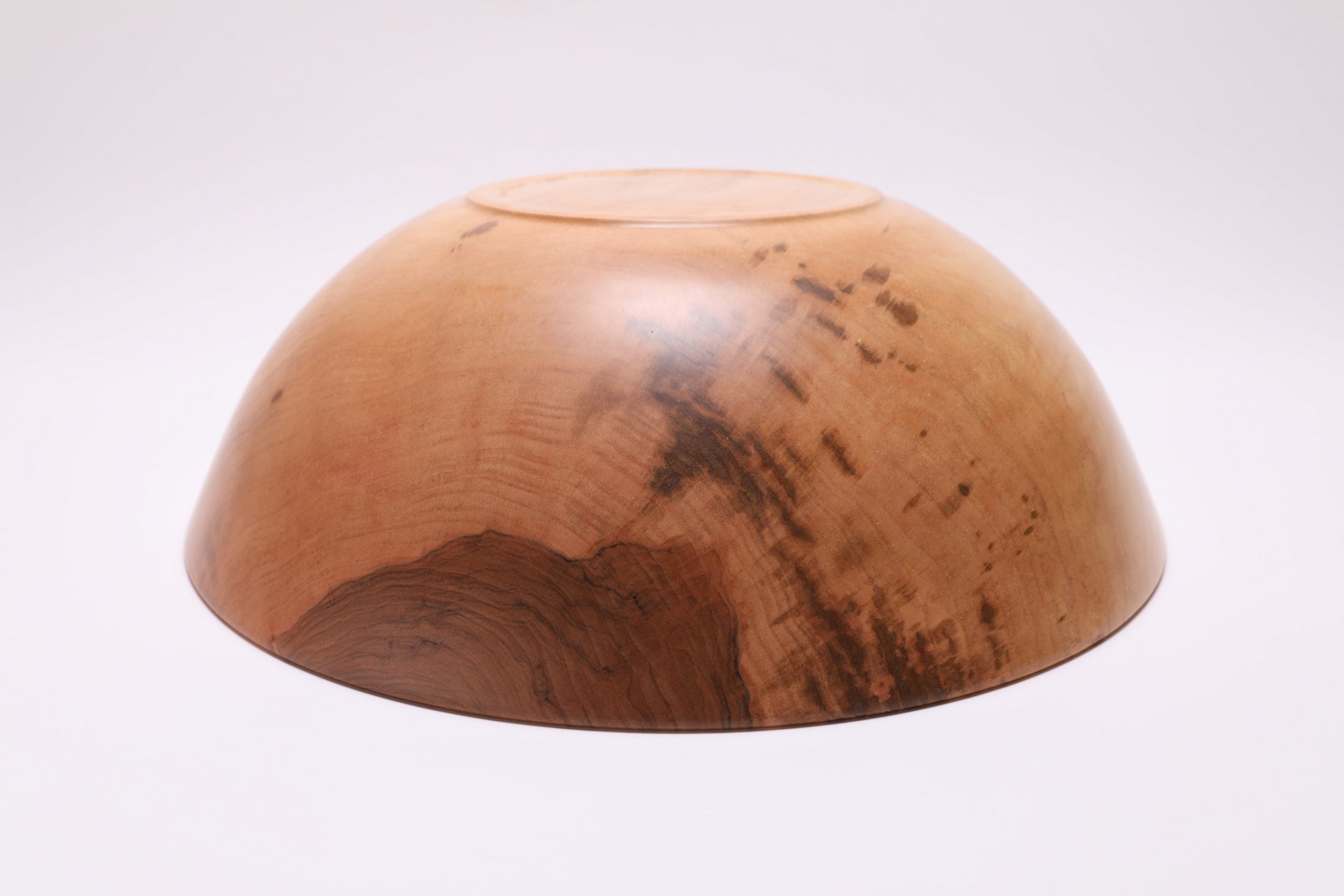 Bottom view of handcrafted large sugar maple bowl showing raised foot and food-safe oil finish