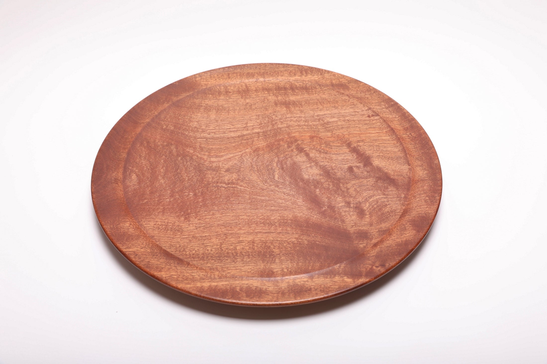 Large Khaya serving platter top view rotated 180°, iridescent grain pattern across full platter surface