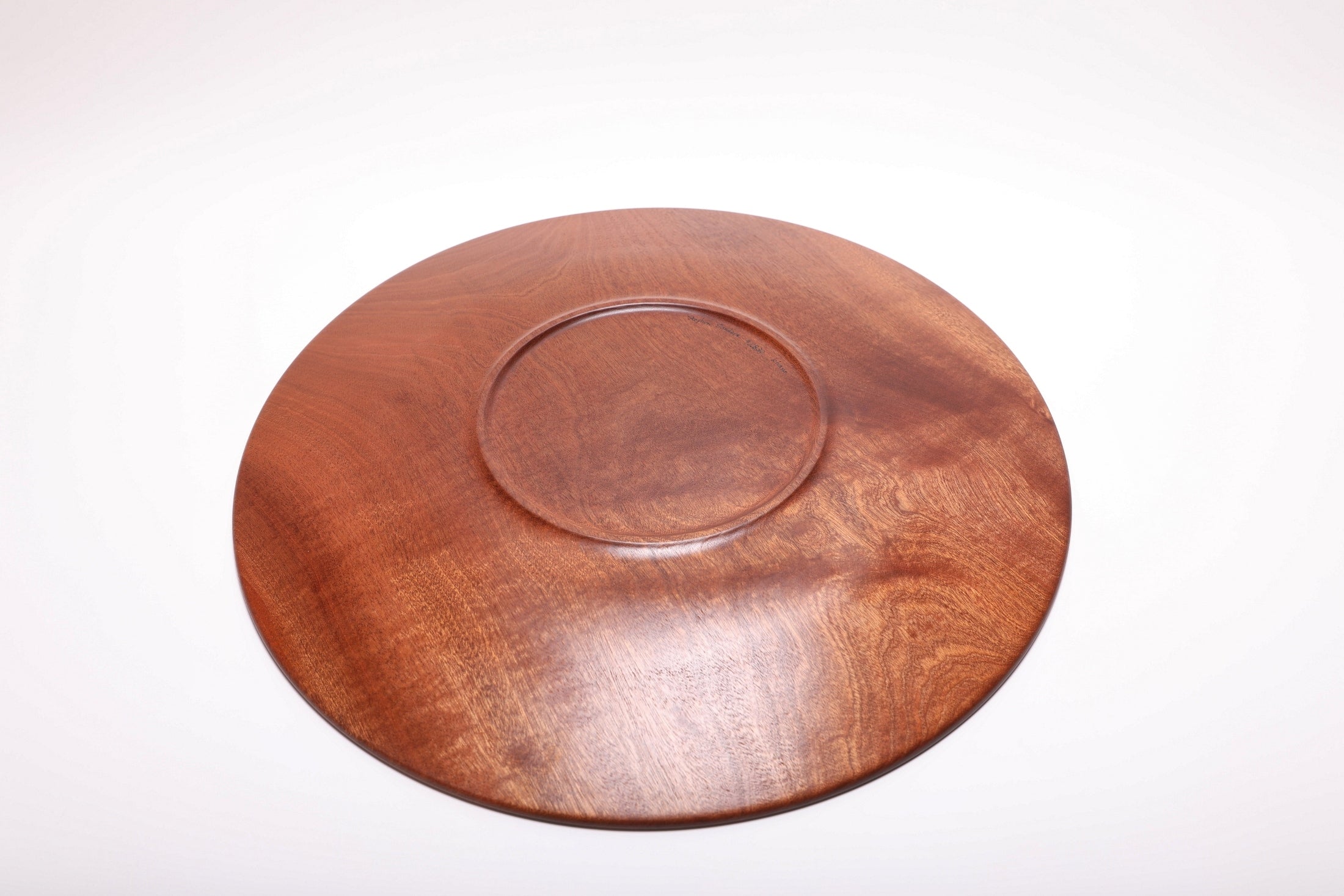 Bottom view of handcrafted large Khaya African mahogany serving platter showing raised foot and food-safe oil finish