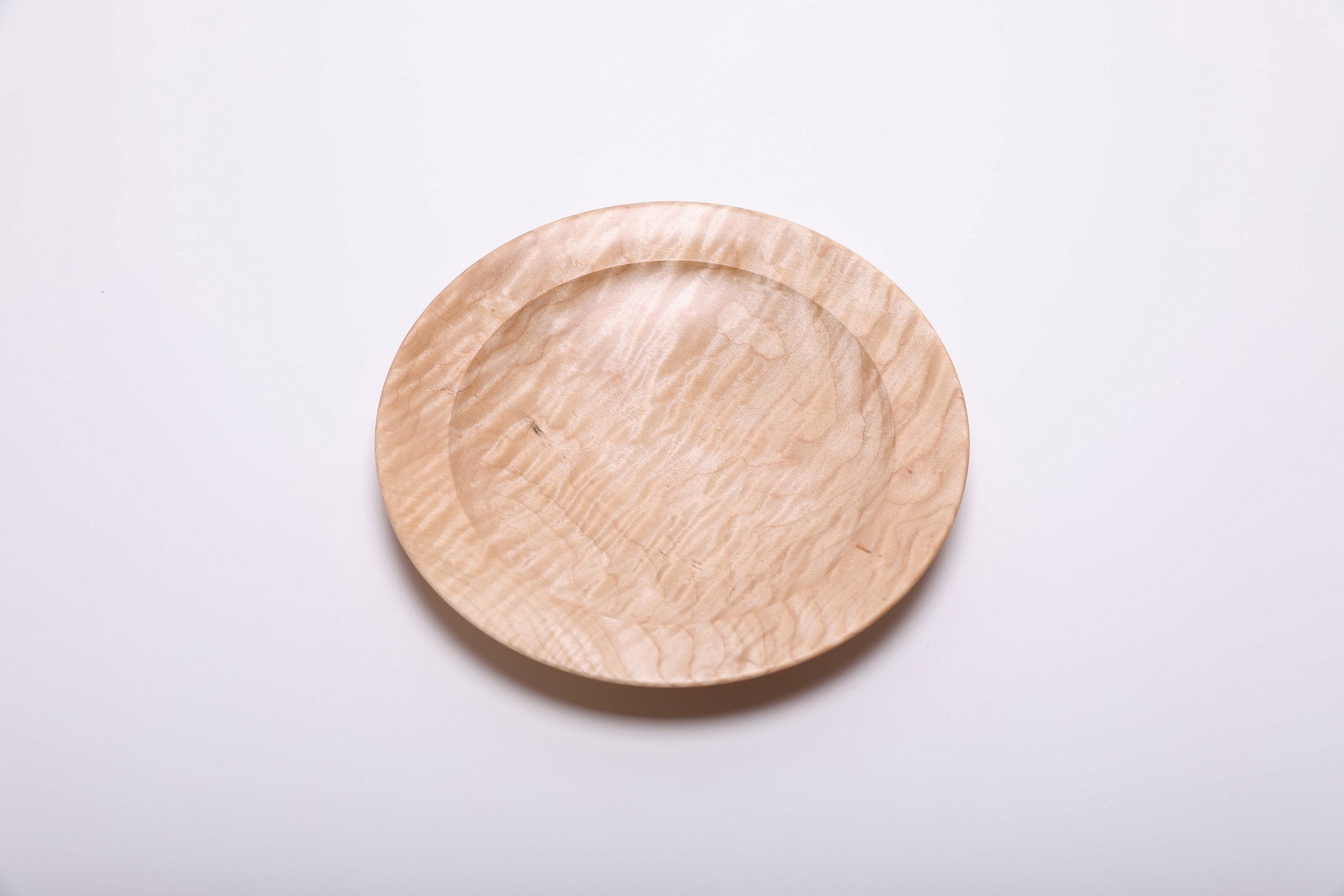 Curly quilted maple shallow bowl top view rotated 45°, dense quilt figure and amber growth ring lines