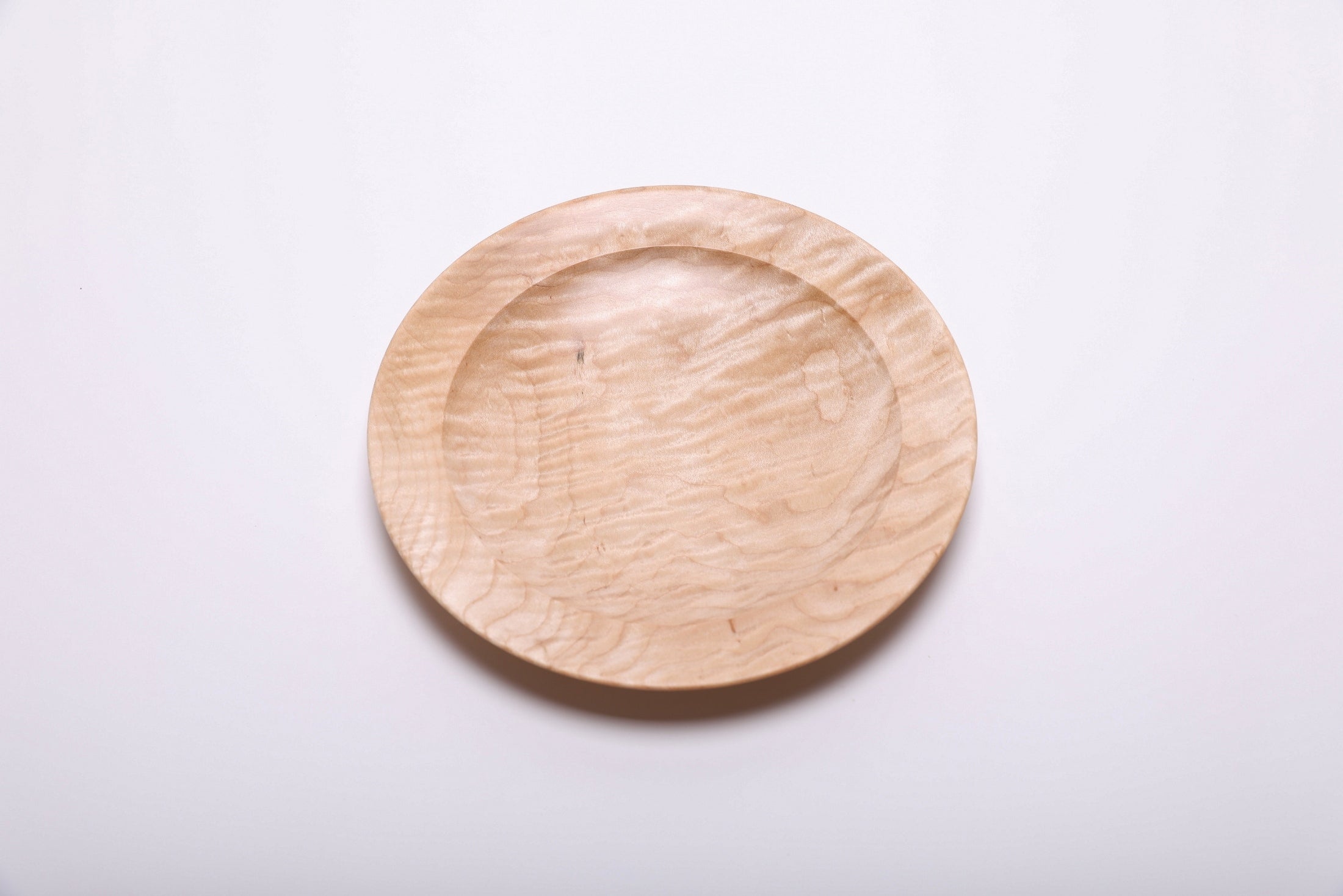 Curly quilted maple shallow bowl top view rotated 90°, chatoyant figure in natural light