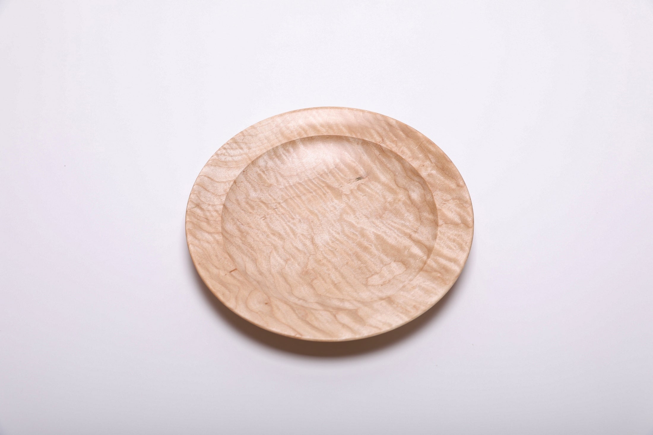 Curly quilted maple shallow bowl top view rotated 180°, full quilt figure visible across bowl surface