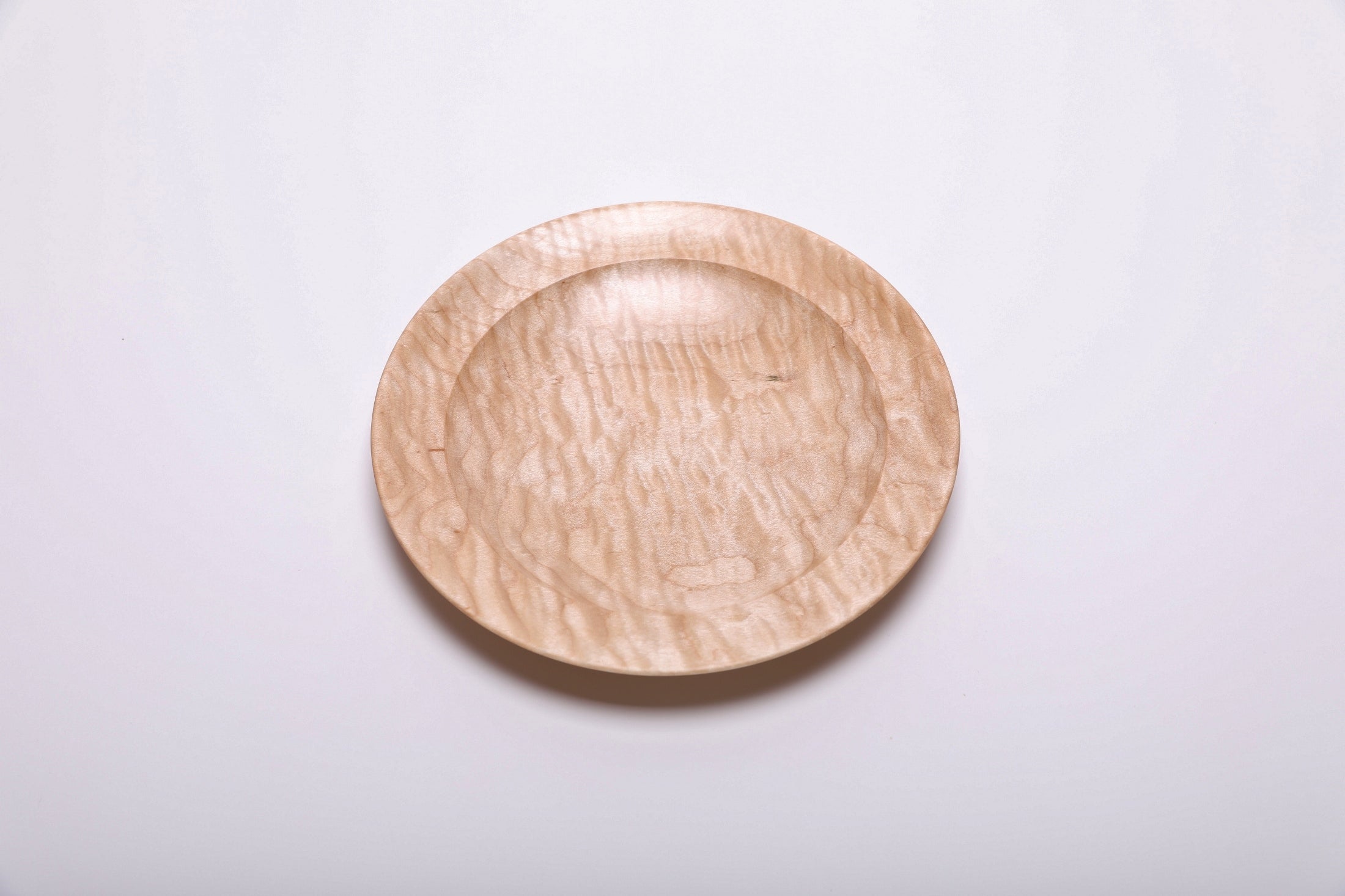 Curly quilted maple shallow bowl top view rotated 225°, amber growth ring transition lines and chatoyant wood
