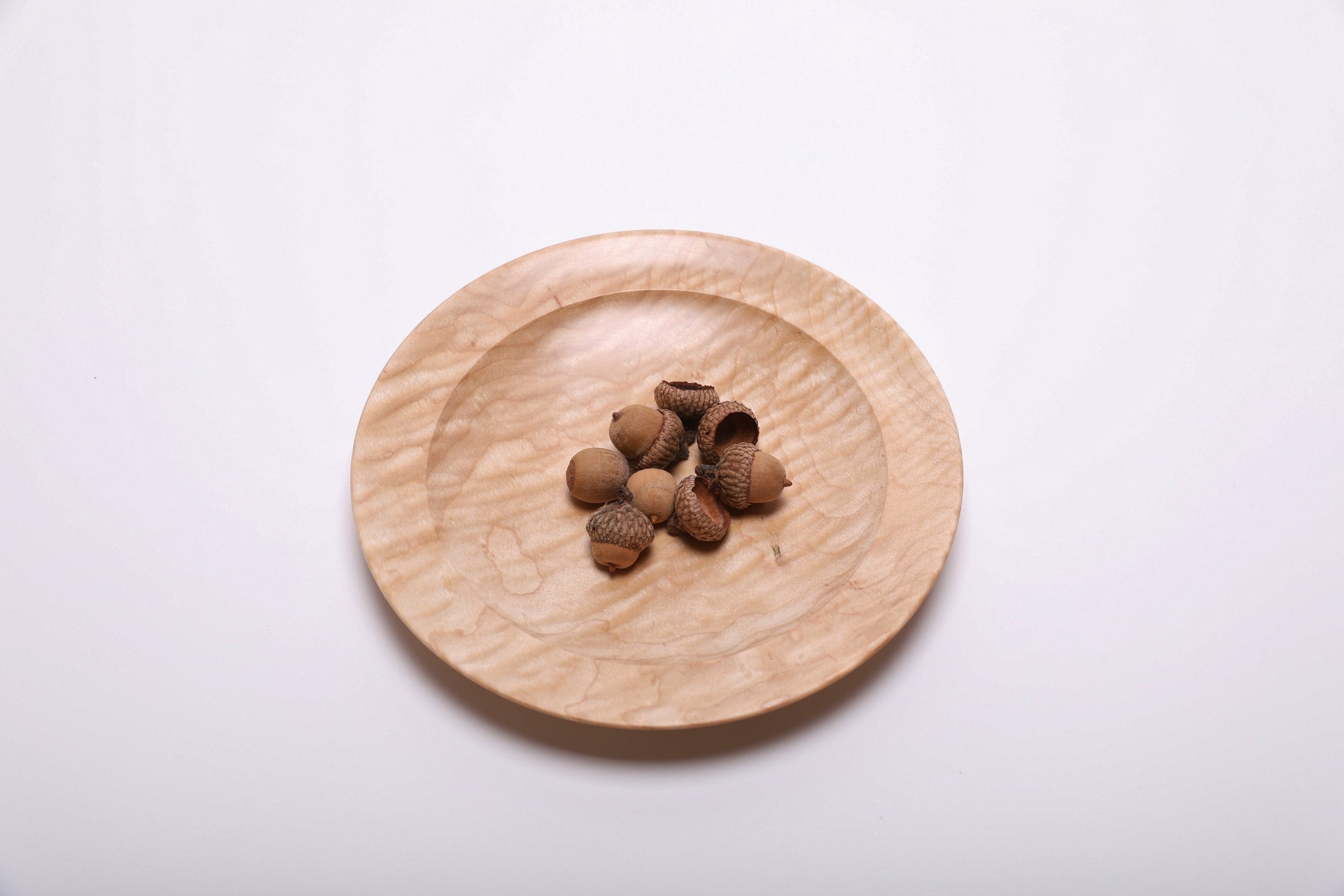 Curly quilted maple shallow bowl shown with acorns for scale – 7 3/4" x 1" handcrafted wood bowl