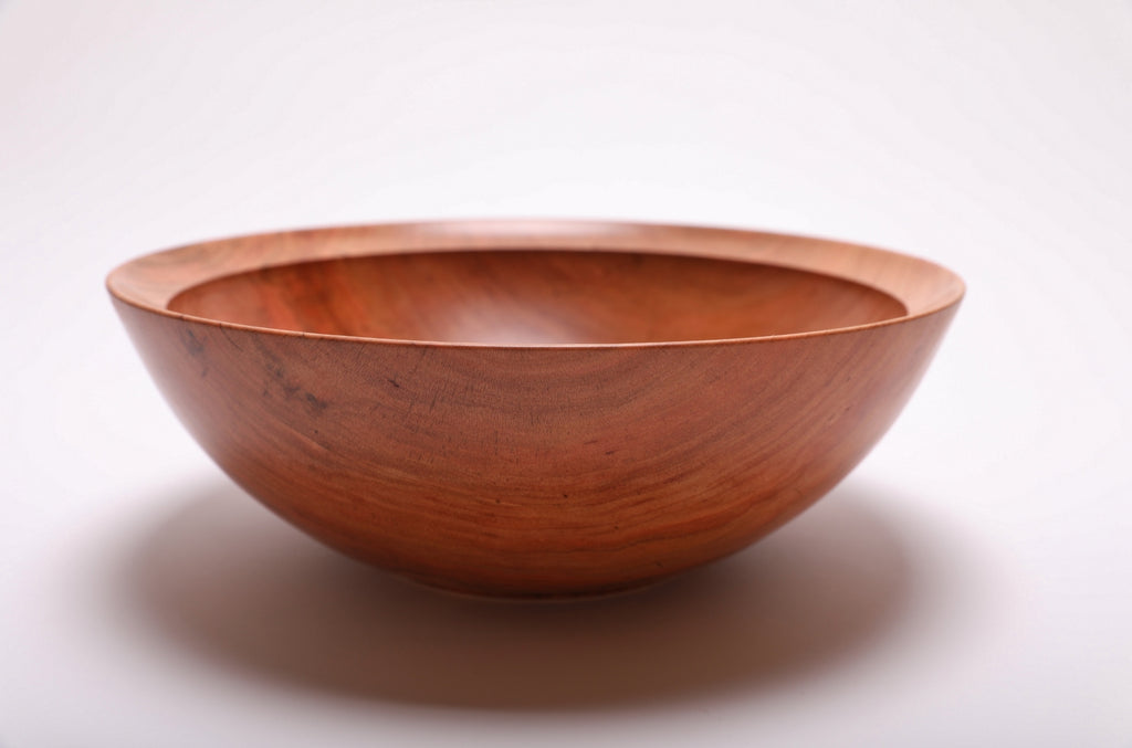 Side view of handcrafted spalted wild black cherry bowl showing curved taper, undercut rim, and raised foot