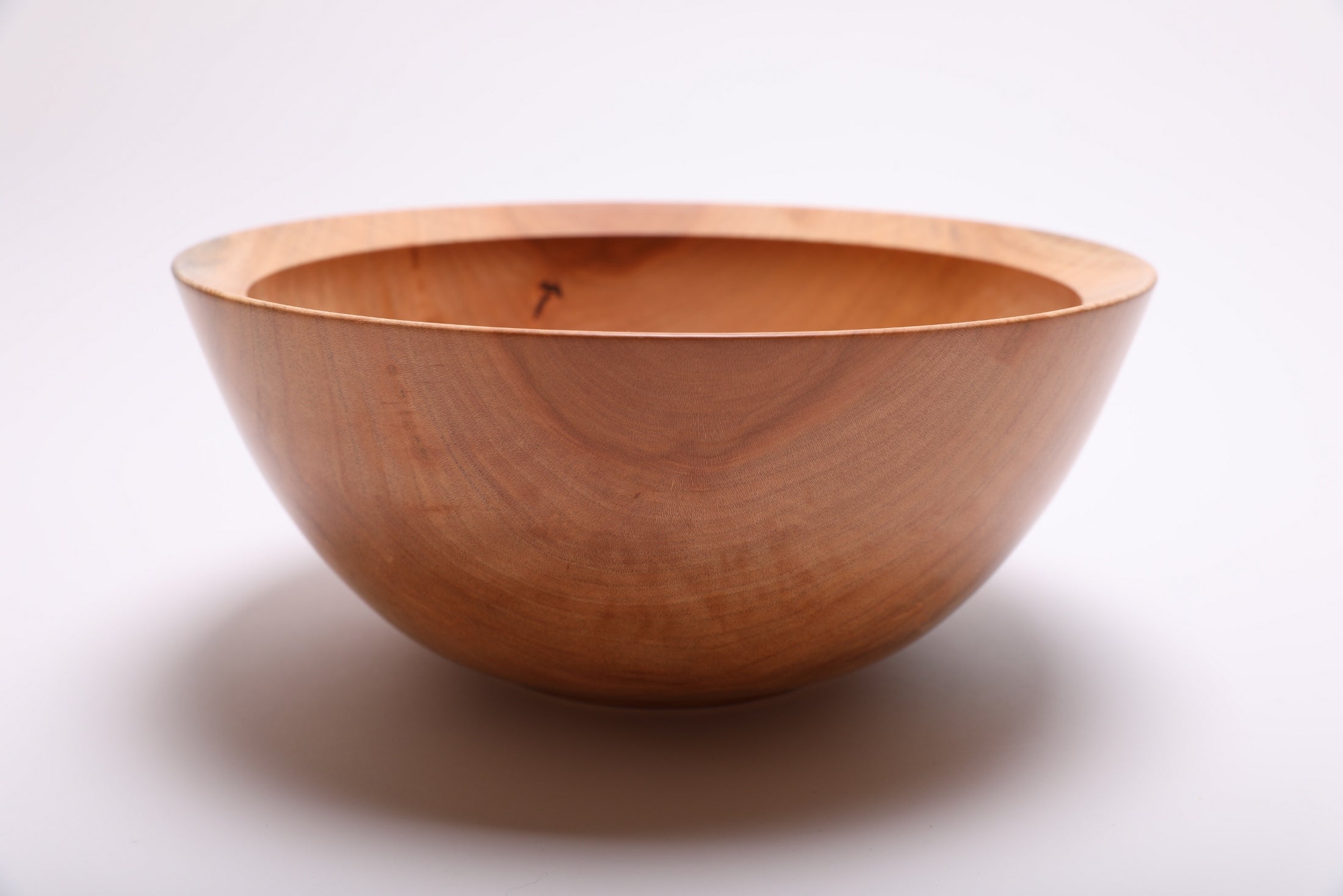 Side view of spalted sugar maple serving bowl showing curved taper profile, undercut rim, and raised foot, made in NC USA