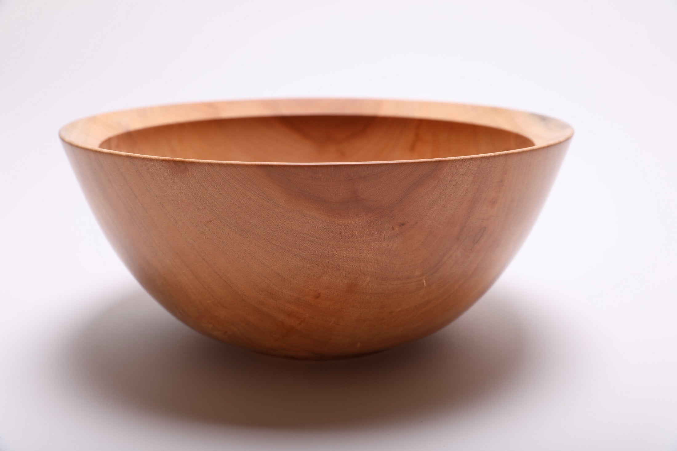 Side view of handmade sugar maple wood bowl showcasing smooth exterior finish and graceful form