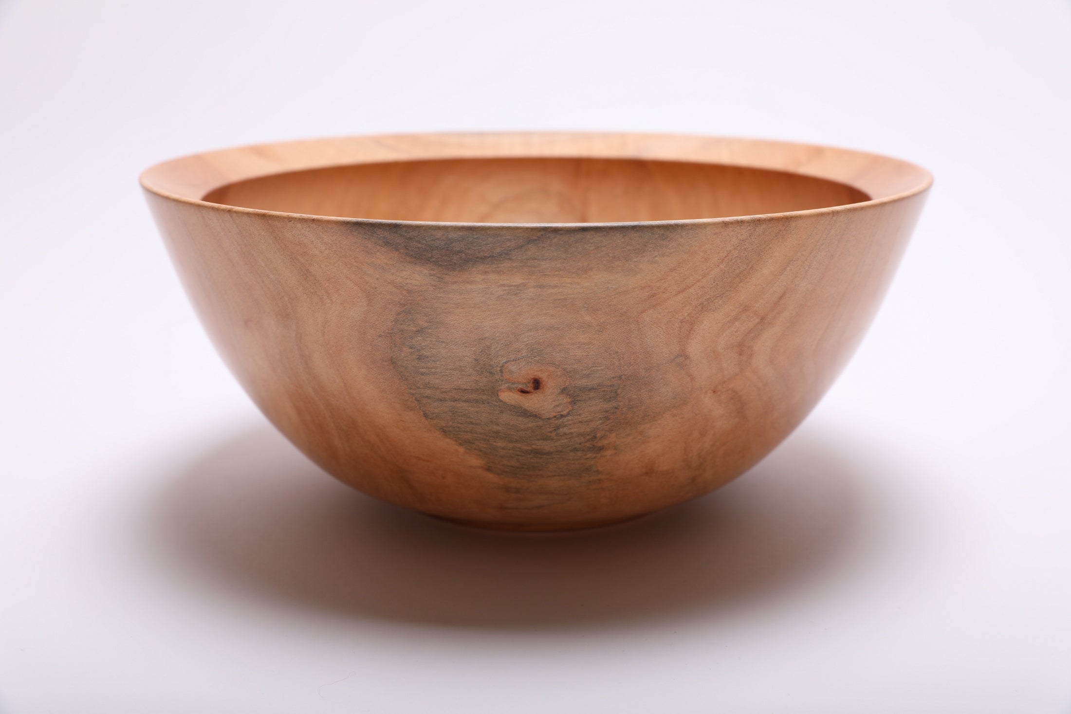 Side angle of spalted sugar maple bowl showing raised foot detail and natural oil finish on exterior grain