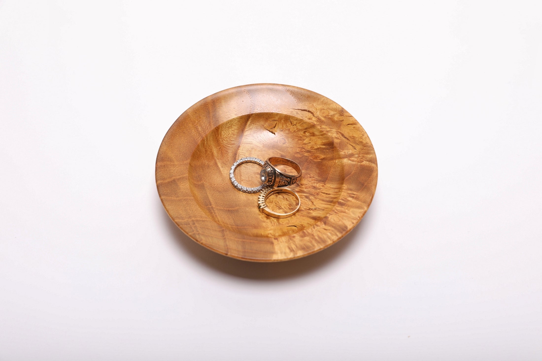 Mulberry burl wood ring dish with three rings showing scale, 4 5/8 inches wide by 1 inch deep, handmade in NC USA