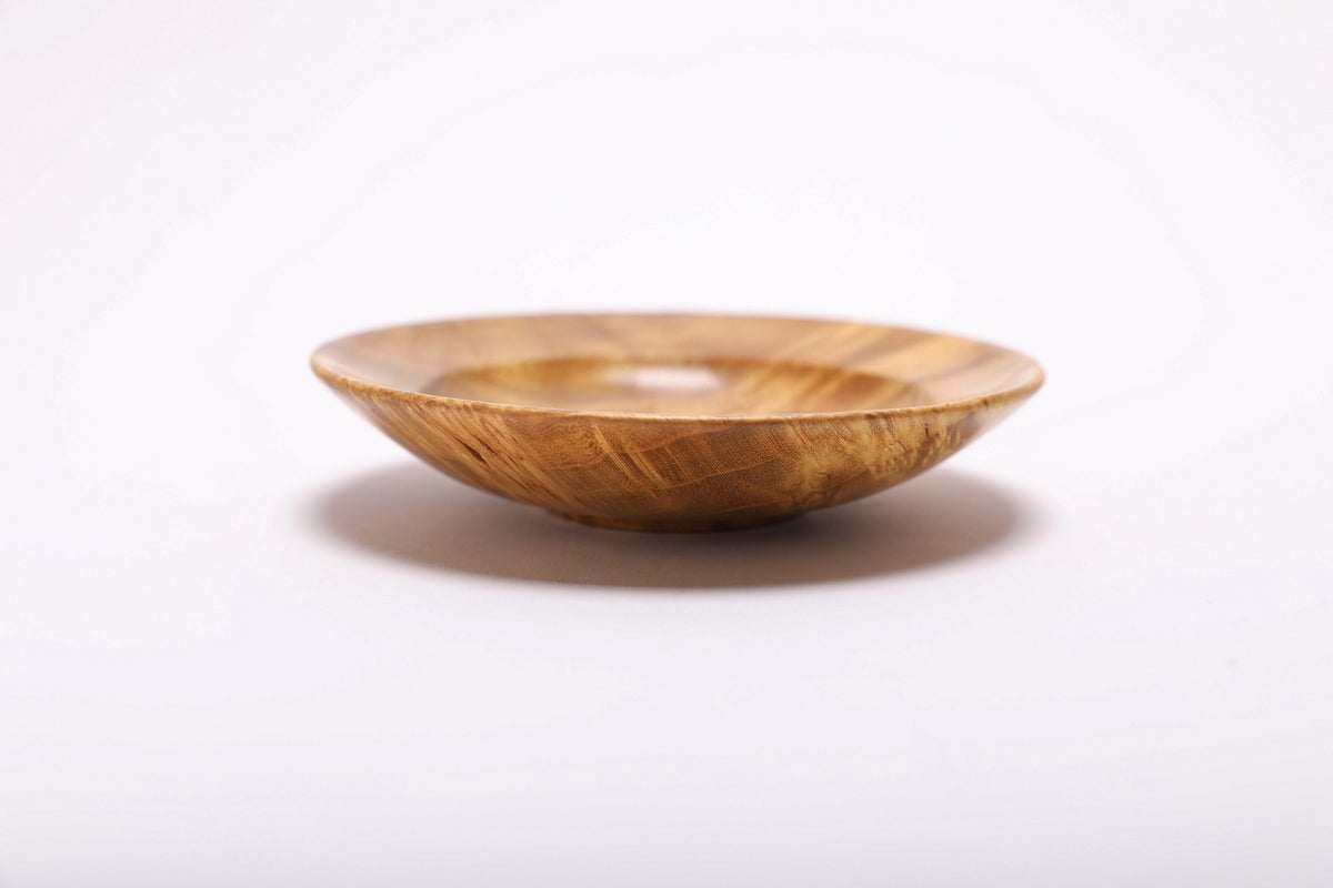 Side profile of hand-turned mulberry burl jewelry dish showing shallow elegant form and natural oil finish on exterior
