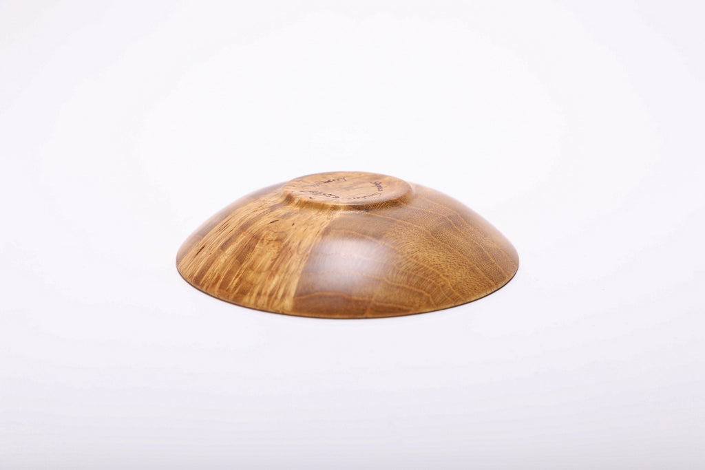 Bottom view of hand-turned mulberry burl ring dish showing small raised foot and natural oil finish on base