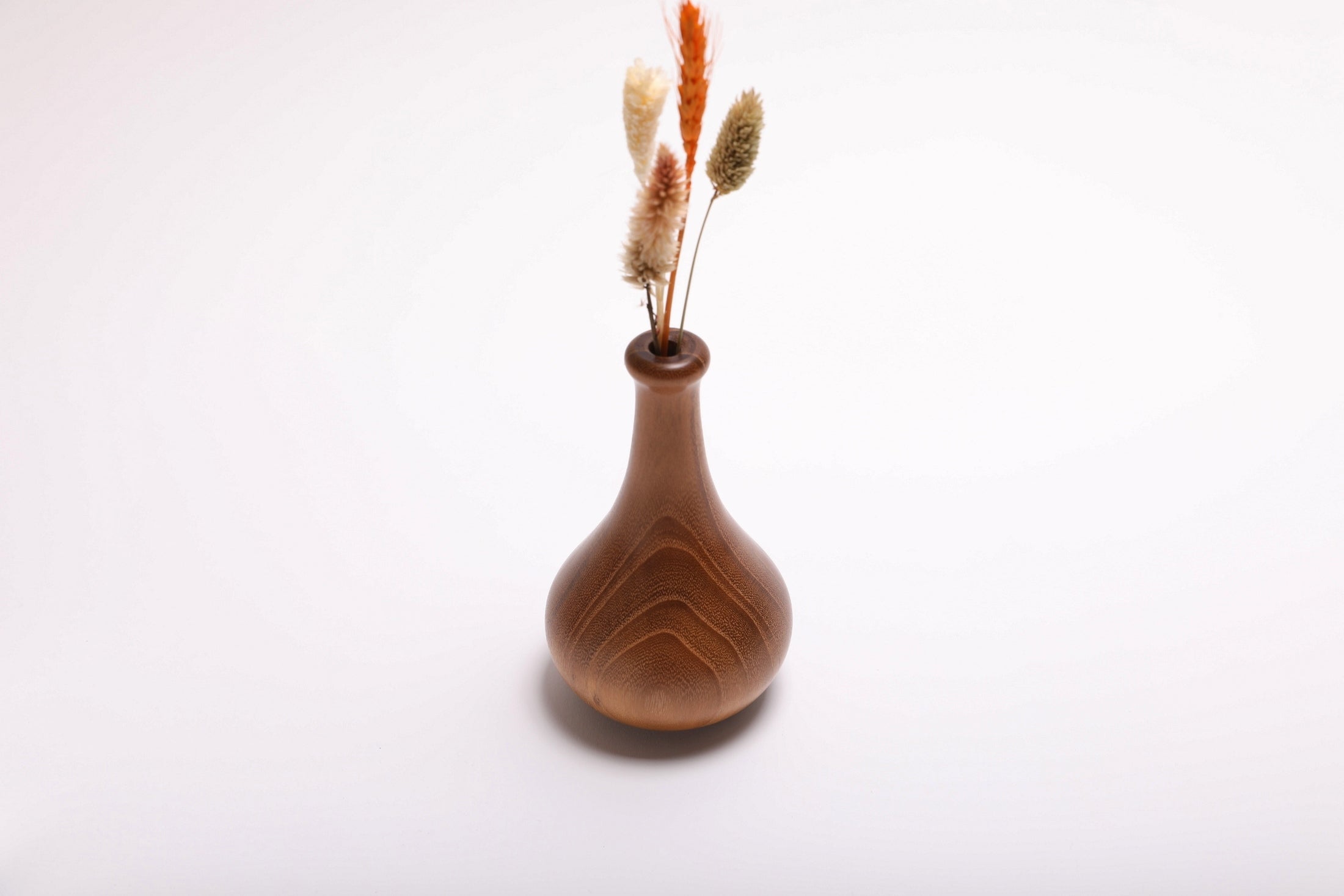 Hand-turned black locust dry vase with dried flowers rotated 90 degrees showing arrangement depth and vase profile