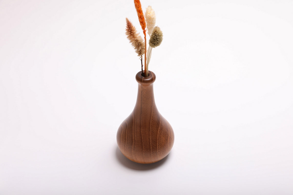 Black locust weed pot with dried flowers arranged in slender neck, front view showing natural botanical display
