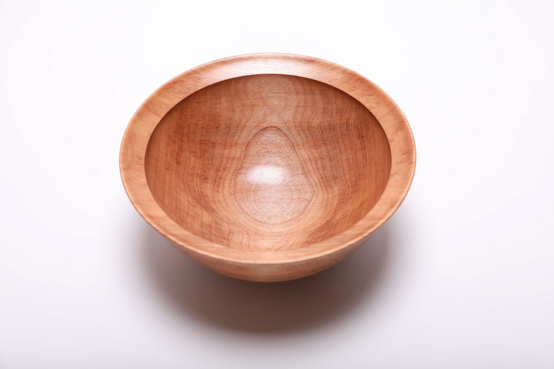 River birch wood bowl top view showing warm cinnamon coloration and iridescent grain, hand-turned with food-safe oil finish, 8 1/8 inches diameter