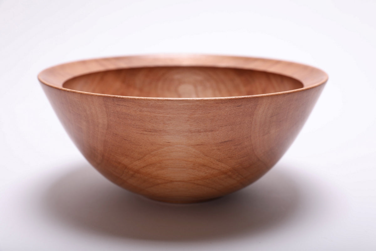 Side view of river birch wood bowl showing rolled rim, curved taper, undercut edge, and raised foot, handmade in NC USA