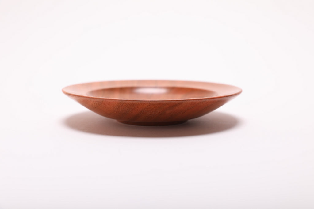 Side profile of hand-turned wild black cherry jewelry dish rotated 90 degrees revealing shallow elegant form and natural oil finish