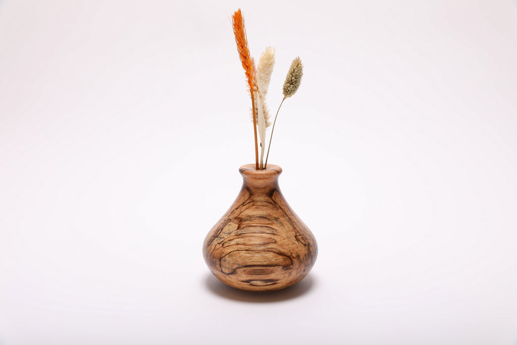 Spalted hackberry wood weed pot with dried flowers, front view showing ink-black spalting lines and gray and amber splotches, 4 1/4 inches tall