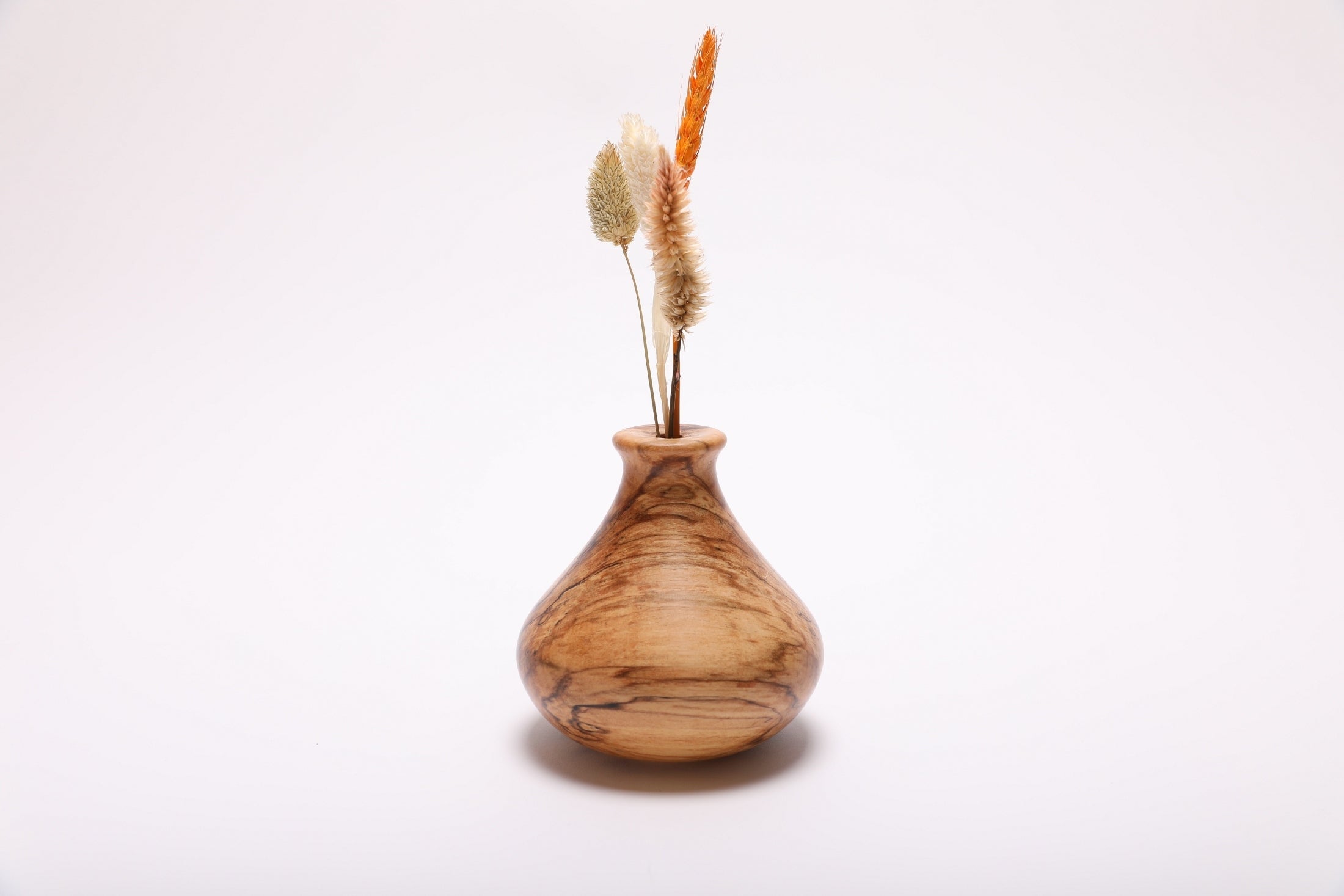 Hand-turned spalted hackberry weed pot with dried flowers rotated 180 degrees showing amber and gray spalted figure
