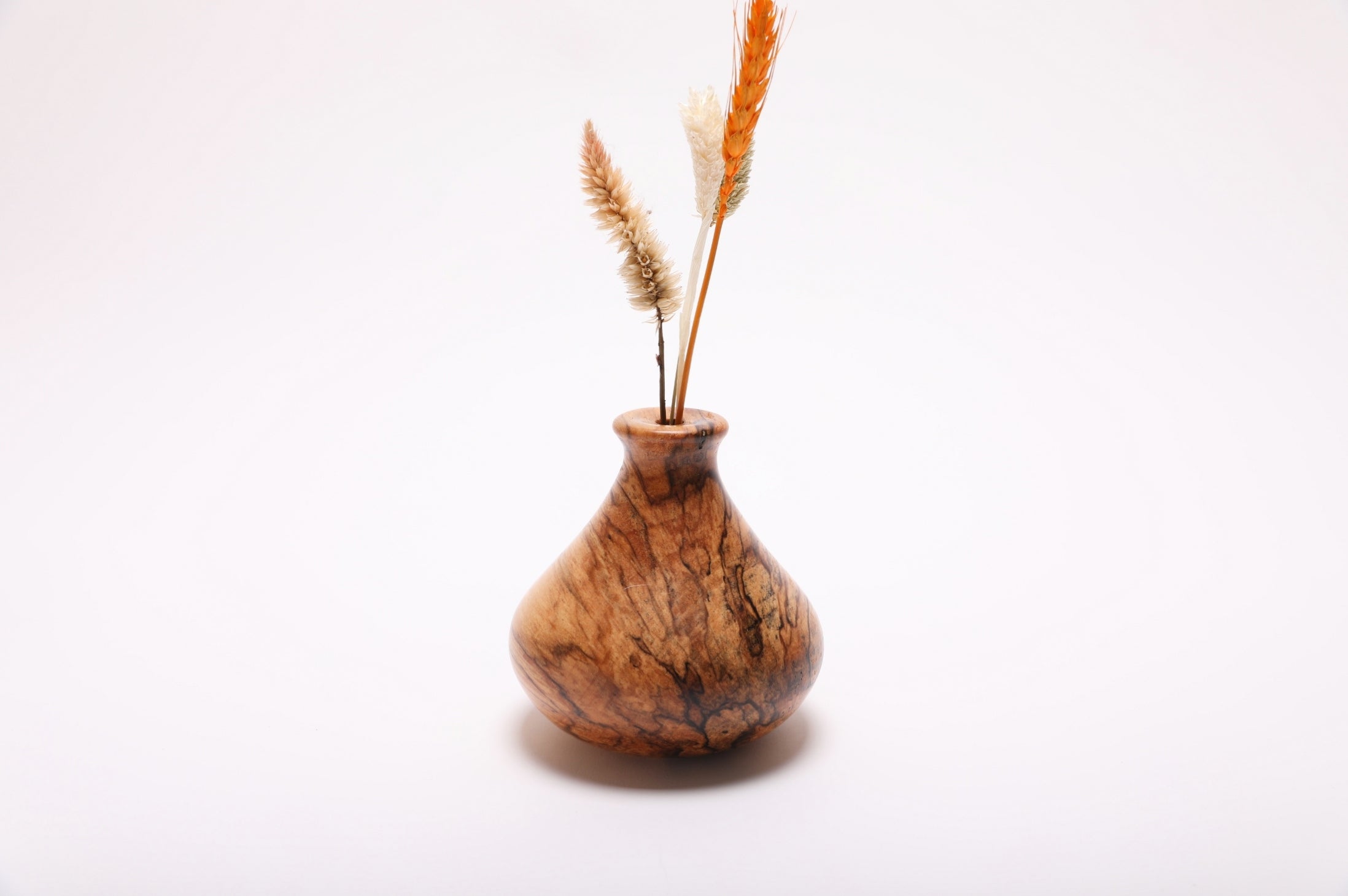 Spalted hackberry dry flower vase with dried flowers rotated 270 degrees displaying ink-black transition lines and natural oil finish