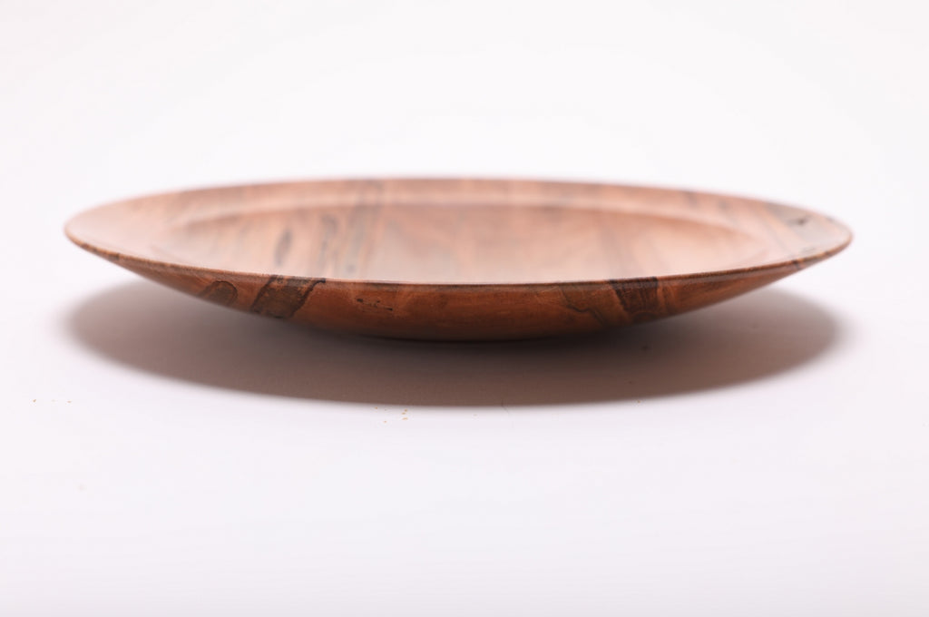 Side view of ambrosia maple shallow dish showing rolled rim, curved taper, undercut edge, and raised foot, handmade in NC USA