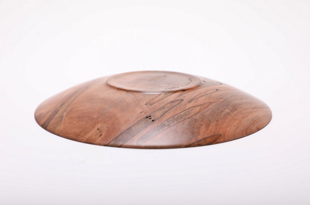 Bottom view of hand-turned ambrosia maple shallow dish showing raised foot and repaired drying crack with natural oil finish