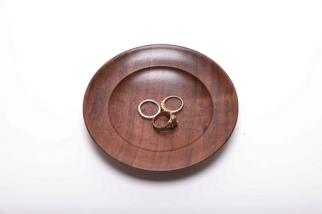 Three rings resting in a hand-turned black walnut ring dish for scale, top view, 5 7/8 inch diameter
